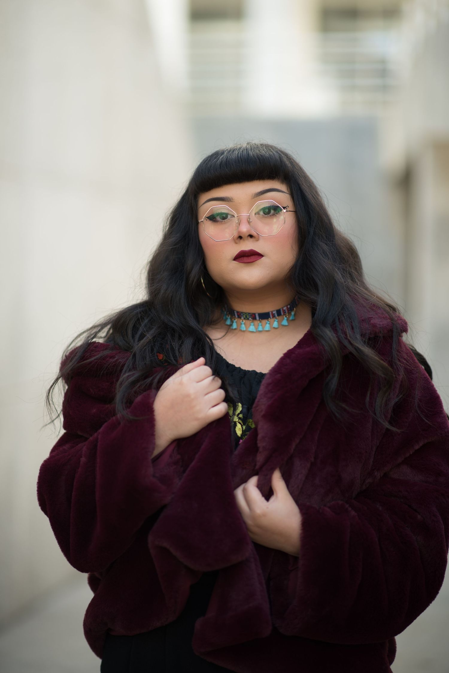 a woman in a fur coat standing in an alley