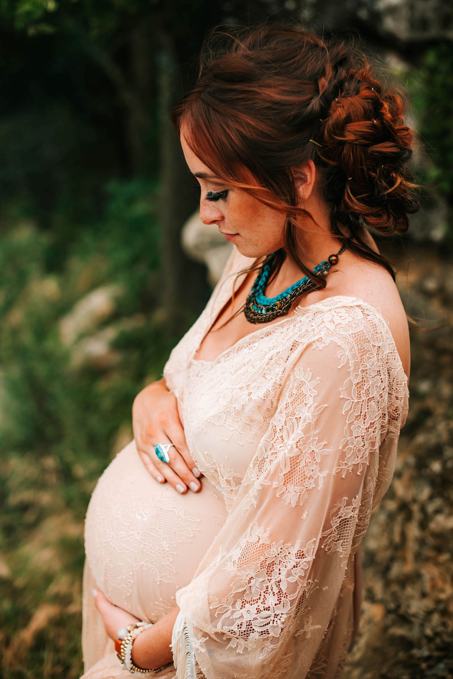 a pregnant mother holding her belly looking down