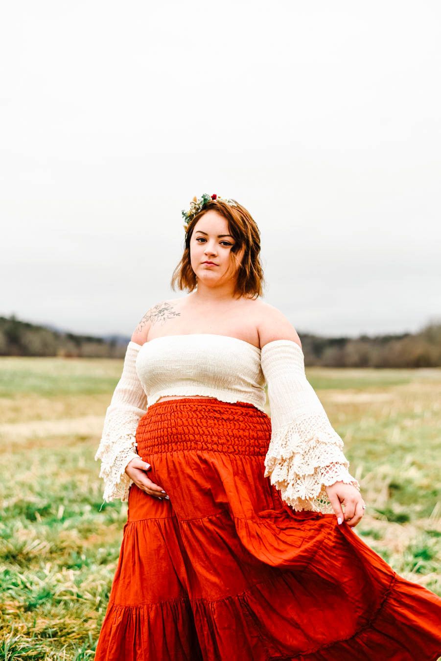 a girl in a bright red skirt and boho top that's pregnant