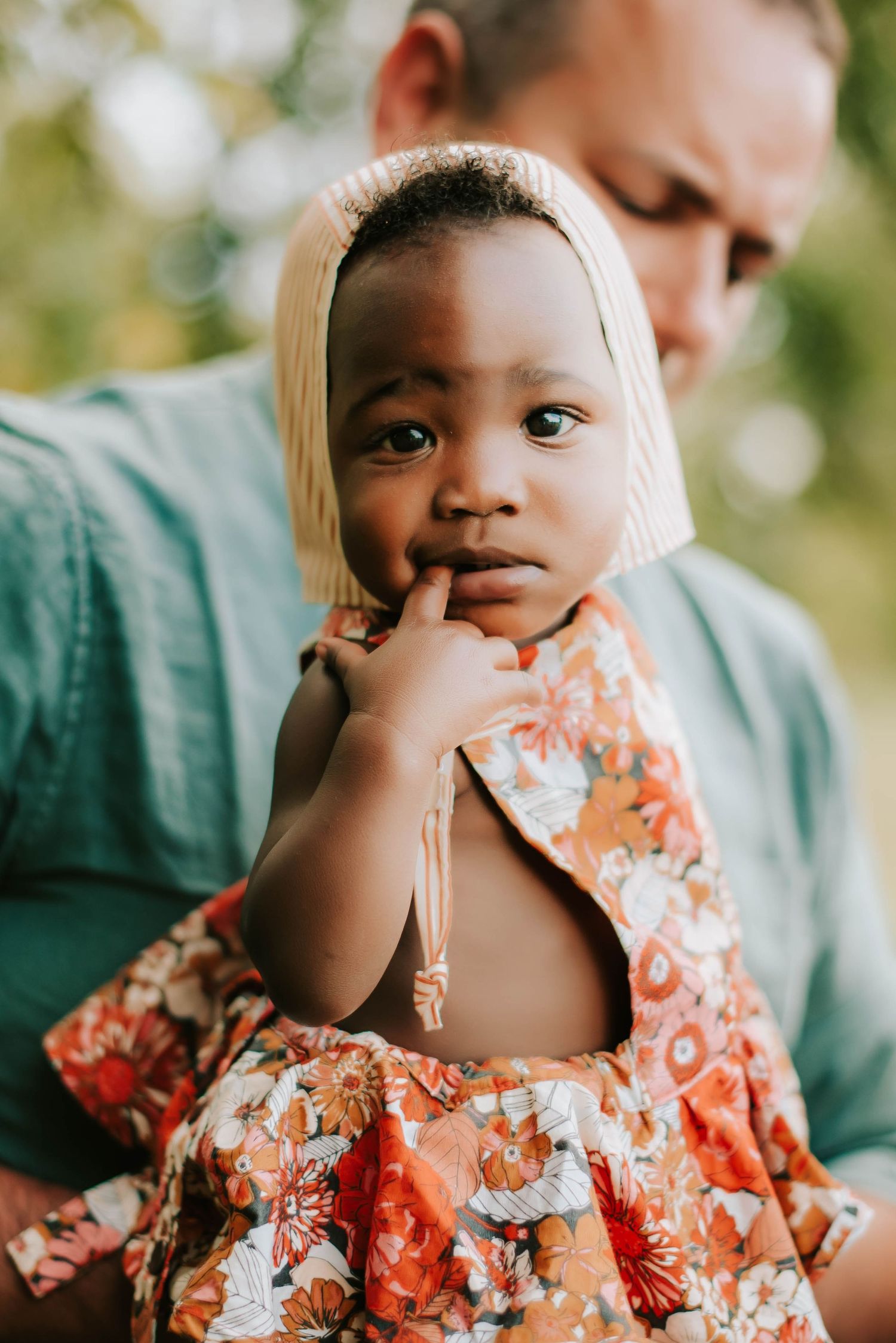 a baby in a bonnet and floral romper
