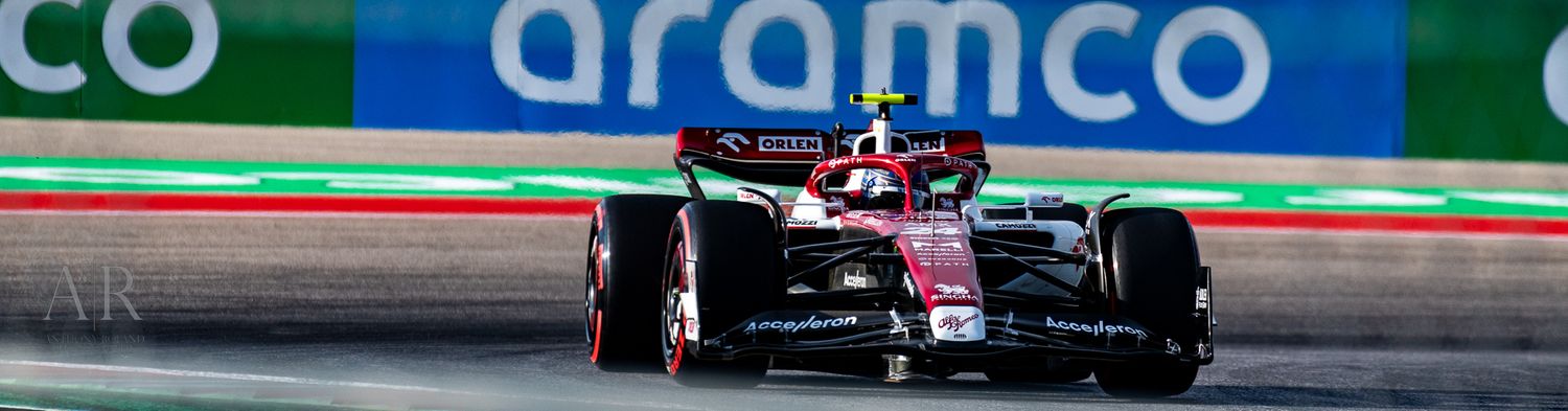 Formula 1 race car with Aramco branding speeds along a racing circuit during competition.