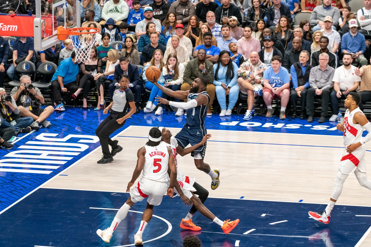 Basketball action on the court with players from both teams positioned for a play.