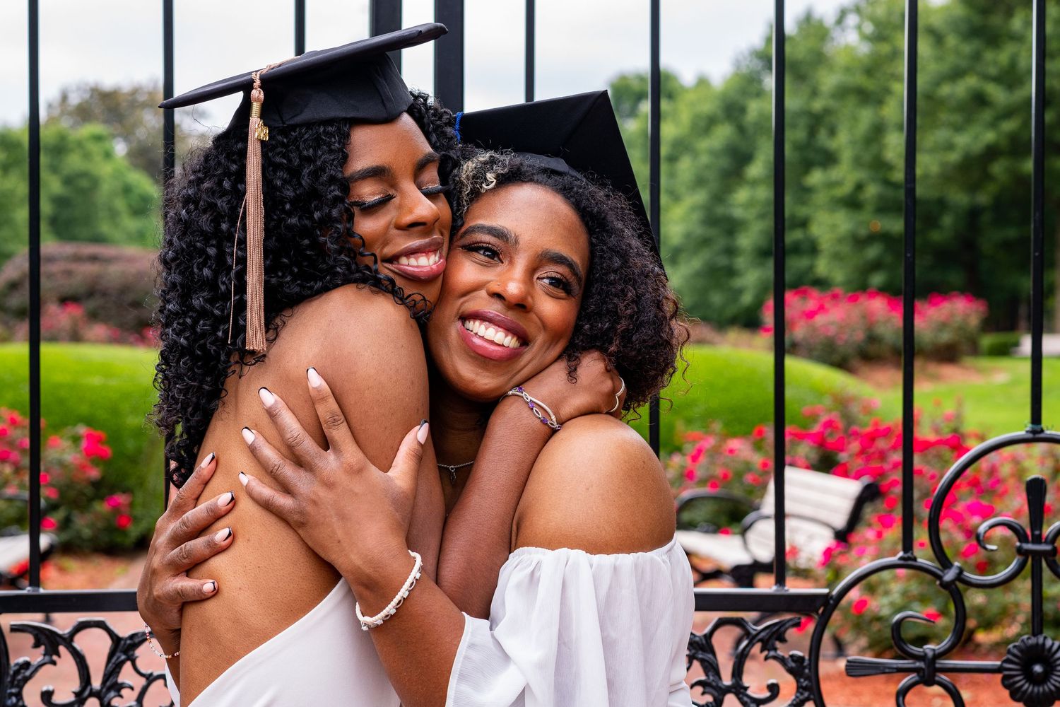 Graduation celebration photos showing joyful embraces outdoors with blooming flowers.