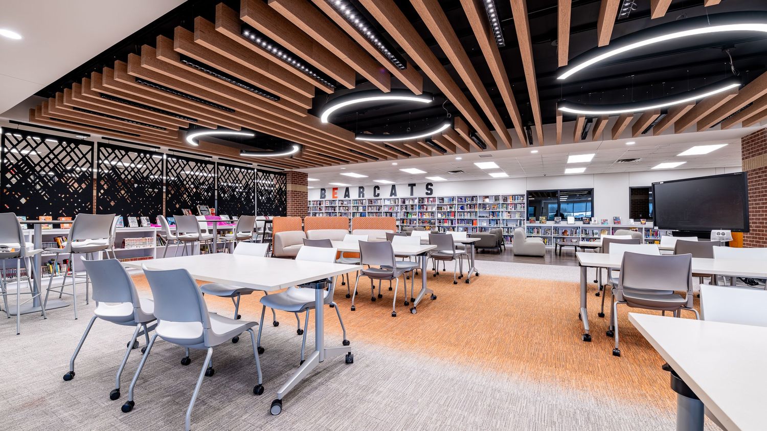 Modern conference space with wooden slat ceiling and flexible seating arrangements.