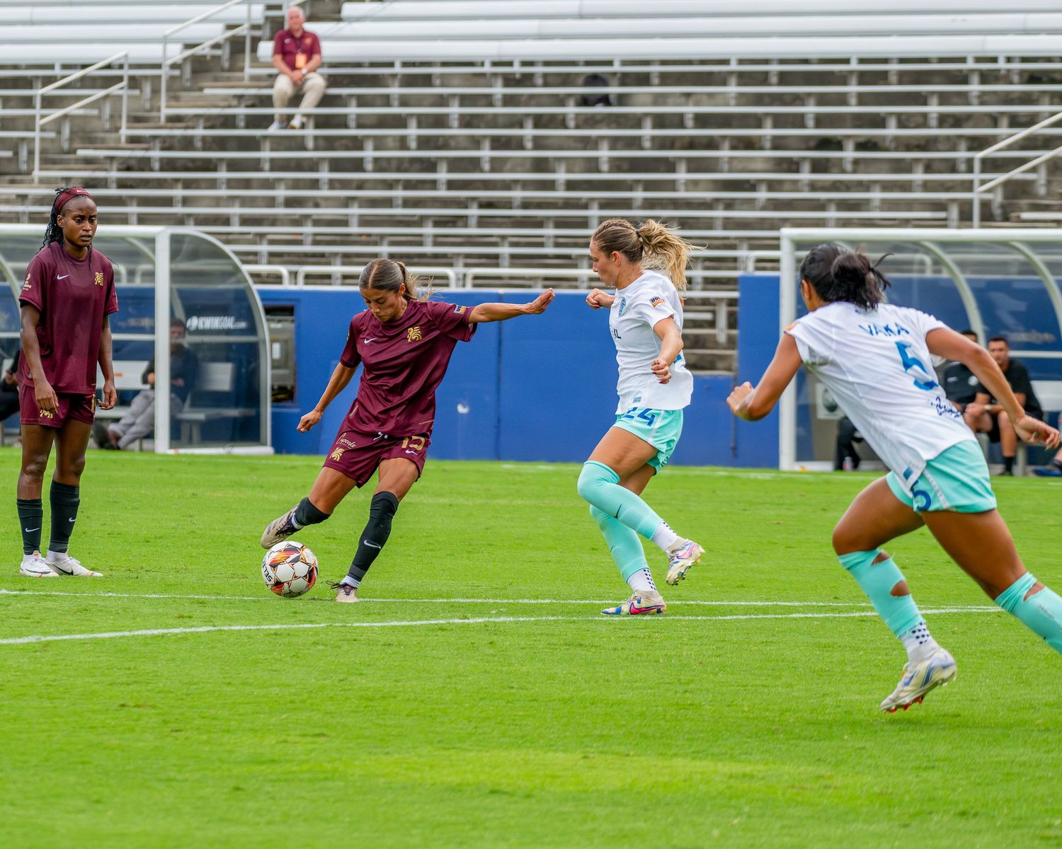 Soccer players from opposing teams compete for control of the ball during a match.
