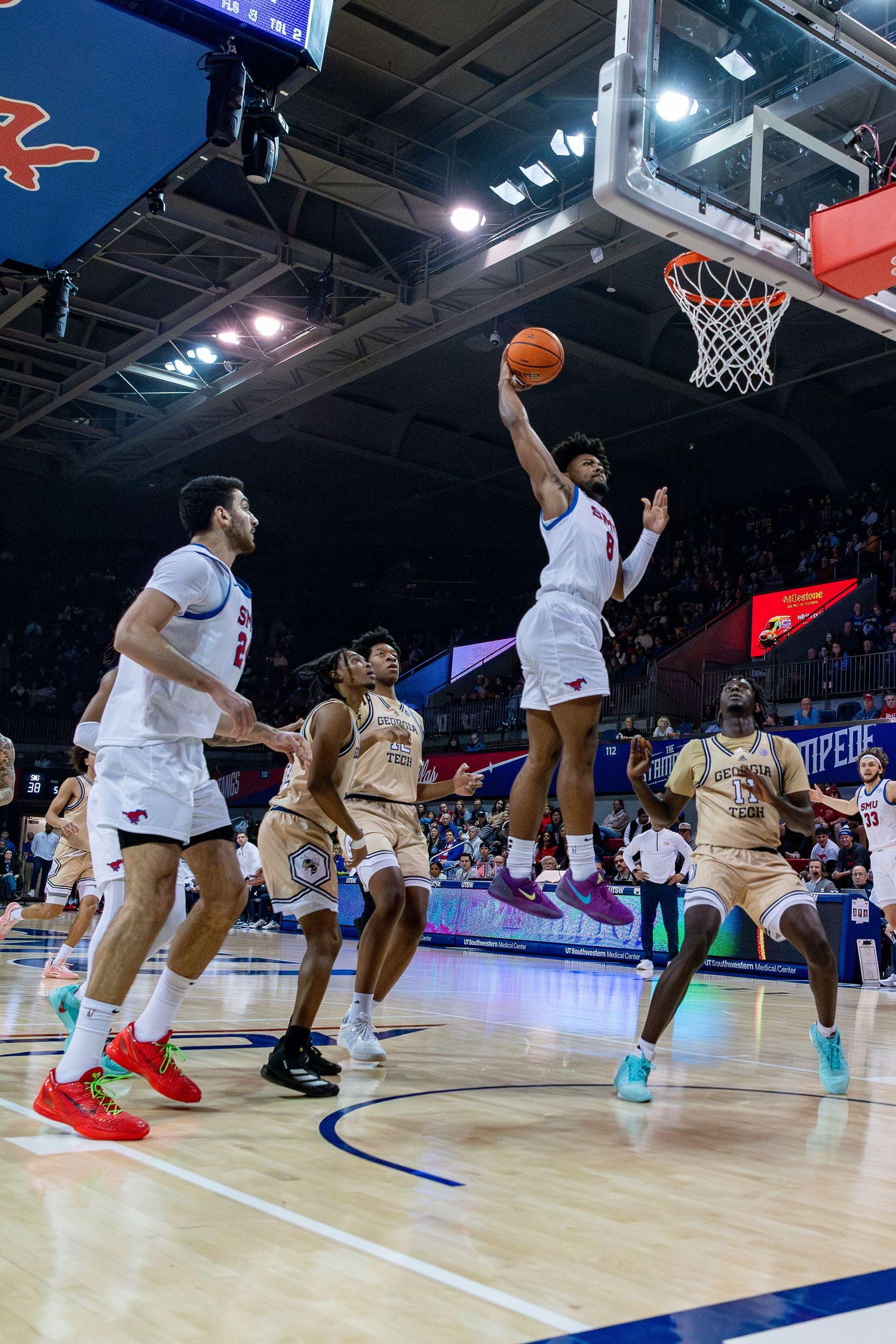 Basketball players in motion during a competitive game on a professional indoor court.