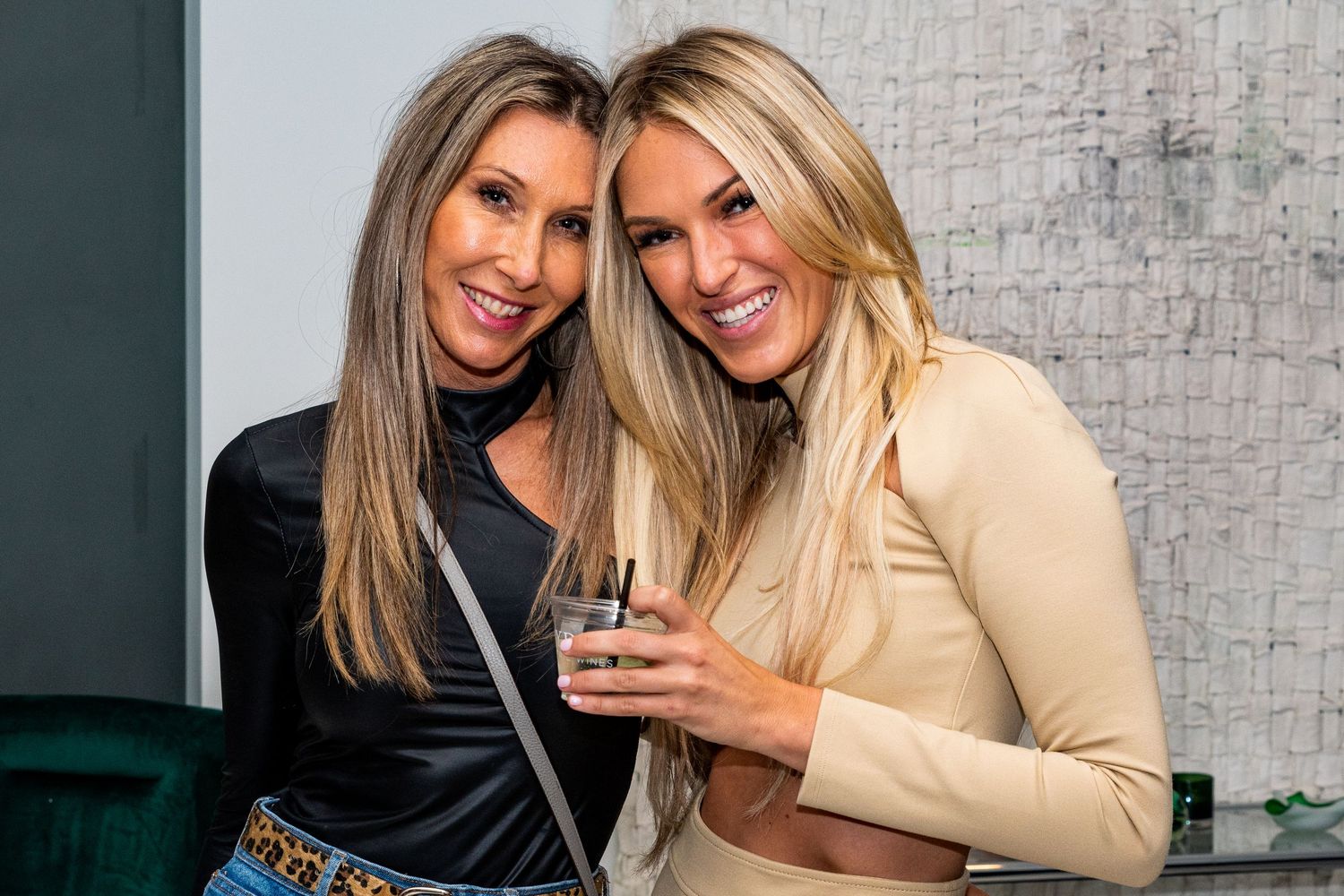 Guests sharing laughs and taking photos at an upscale social gathering.