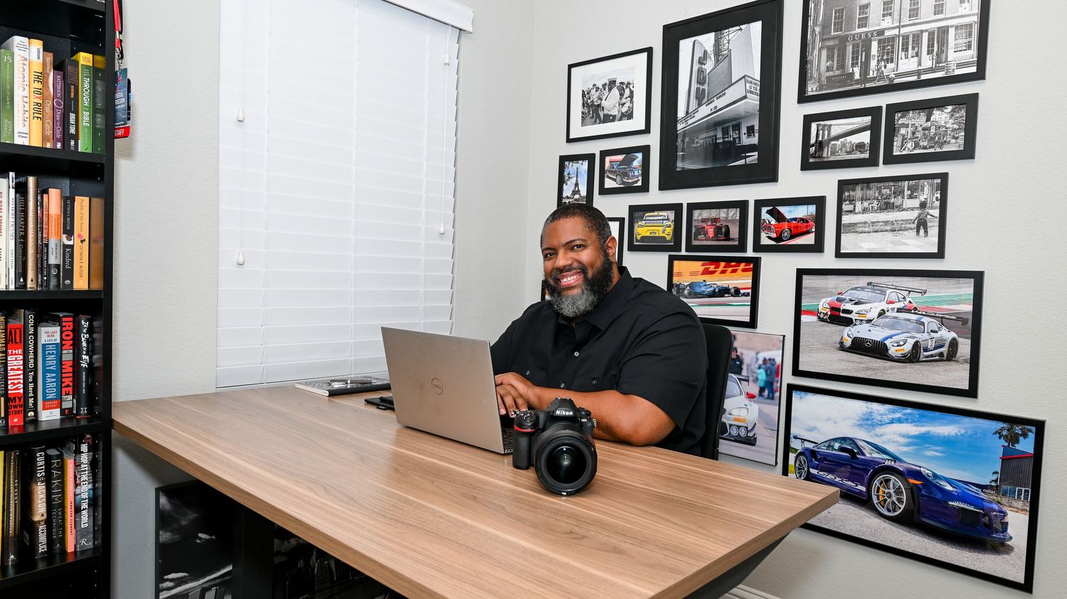 Panoramic view of an office workspace with photography equipment and computer monitors.