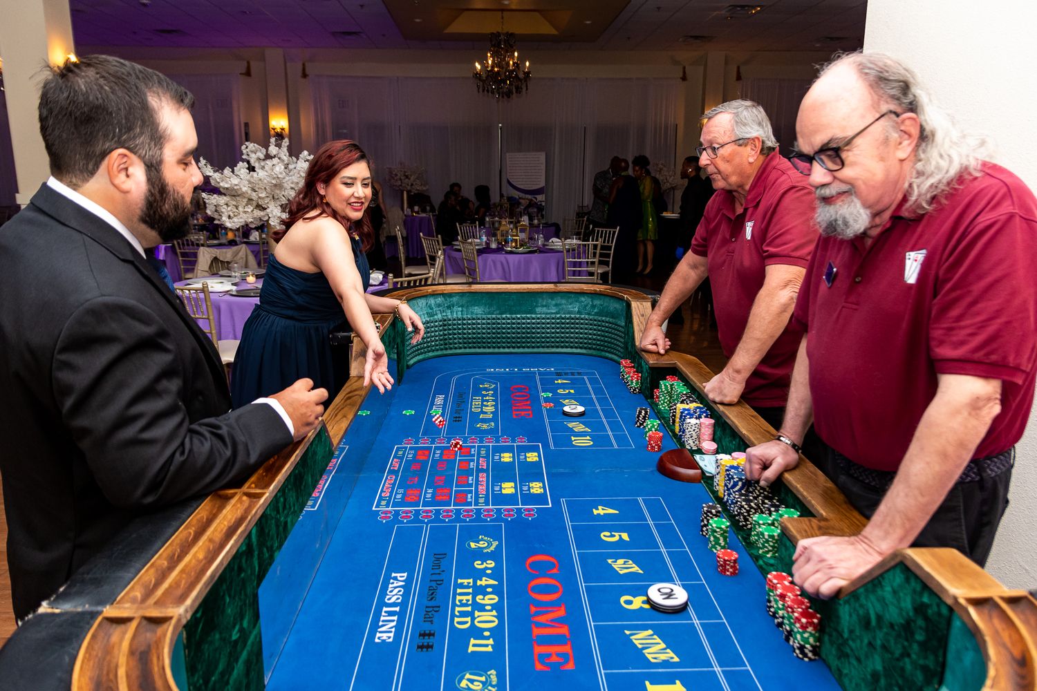 Casino craps table with players gathered around during an event.