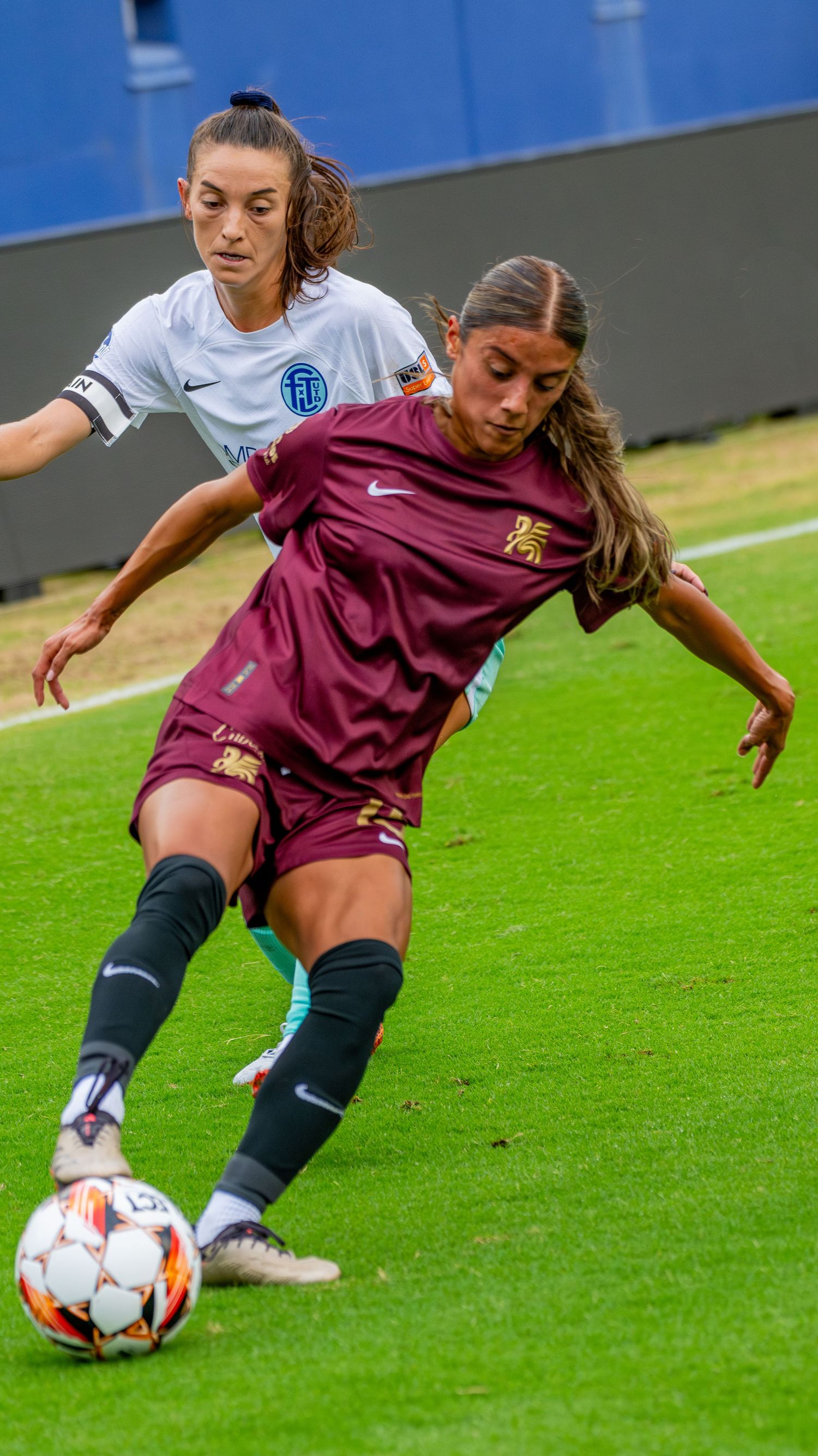 Soccer players battle for possession of the ball during an intense match on a green grass field.