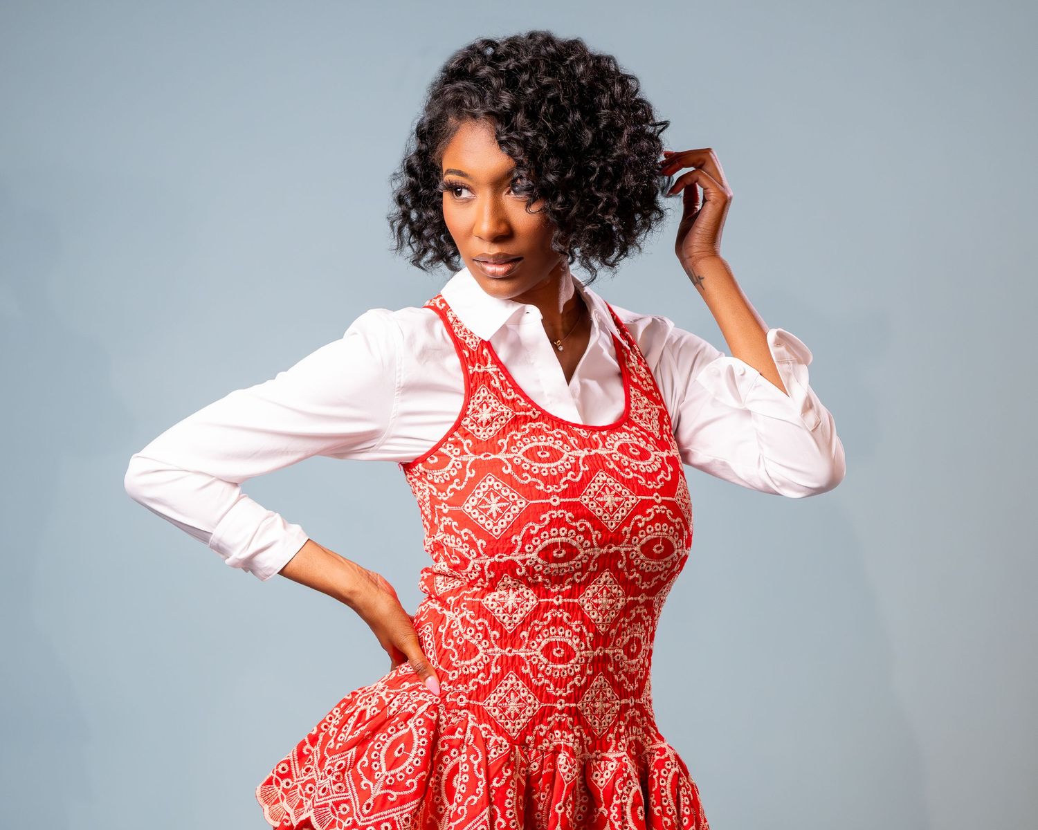 A person in a red and white patterned dress poses playfully against a gray background in multiple shots.