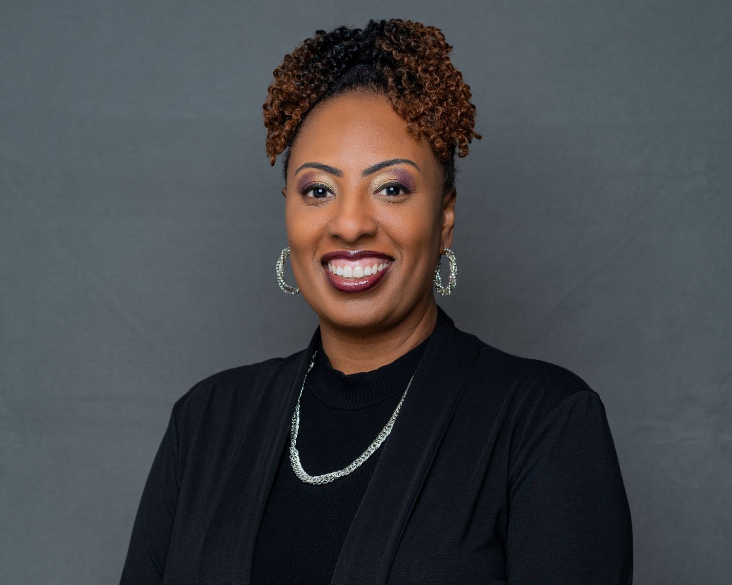 Professional headshots in business attire against grey backdrop showing confident poses.
