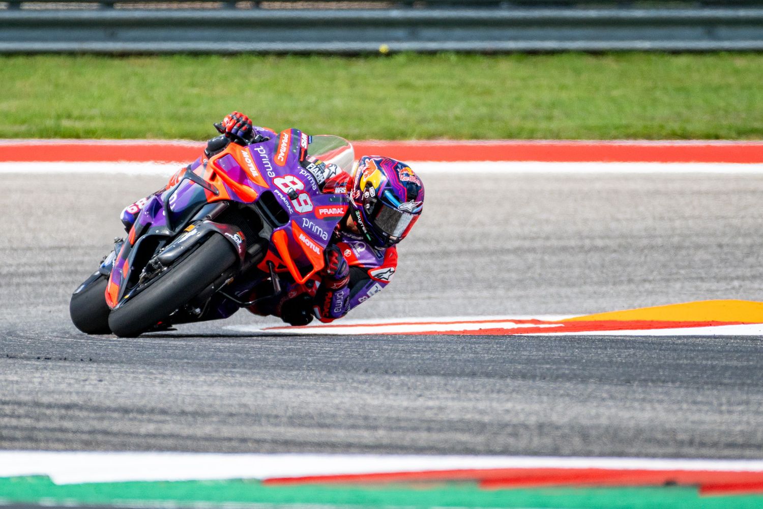 MotoGP racing bikes leaning into corners at high speeds on a race circuit.