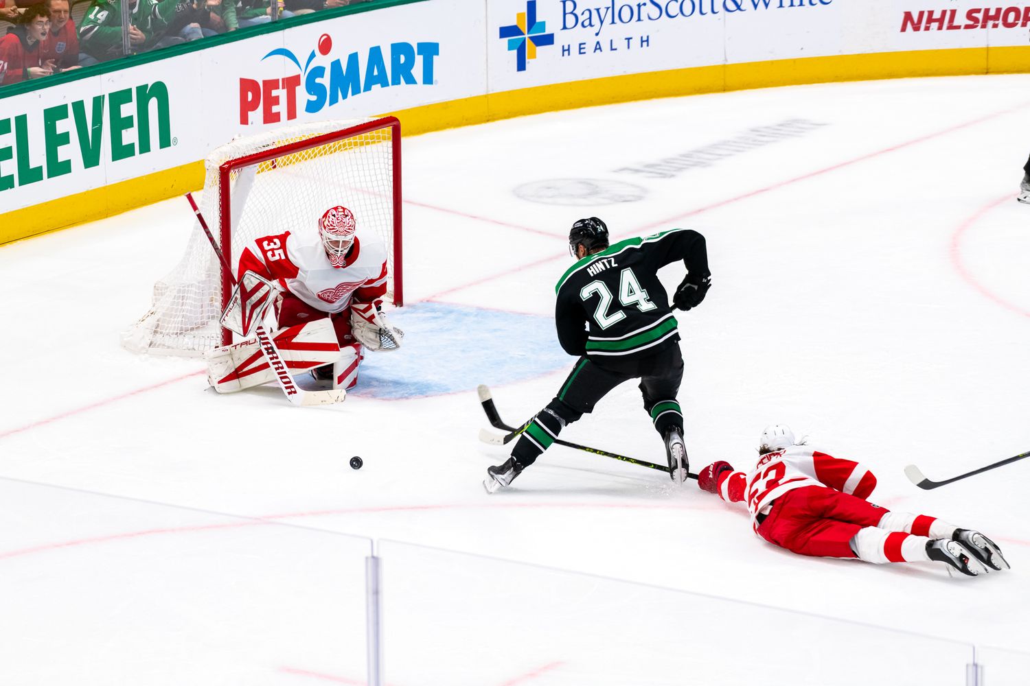 NHL hockey players compete near the goal with PetSmart and 7-Eleven advertising visible.