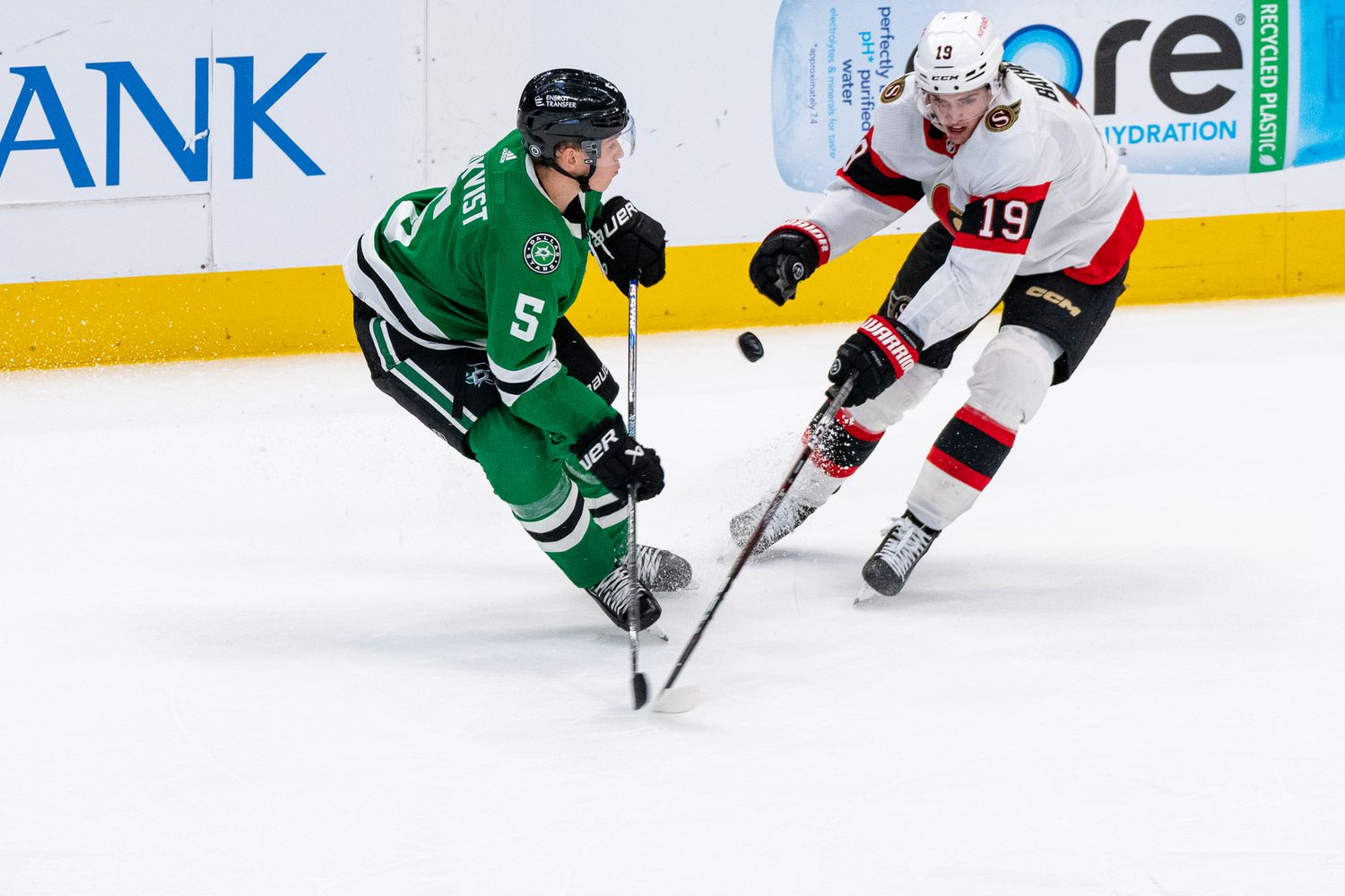 Hockey players from opposing teams battle for the puck during an intense NHL game.