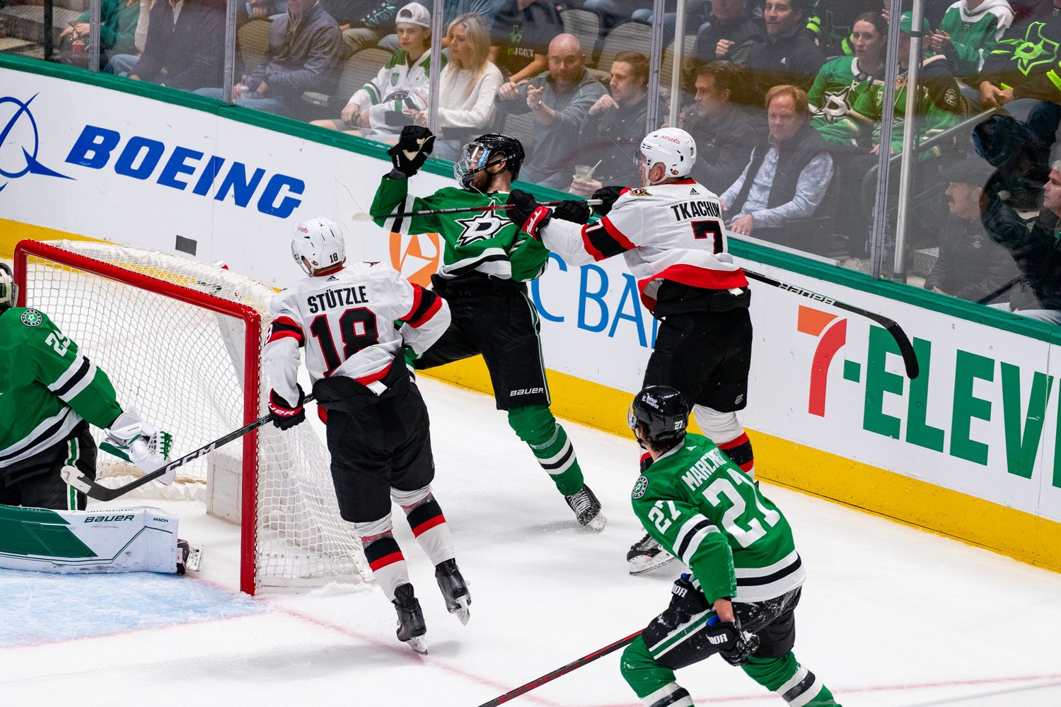 Hockey players collide along the boards during intense NHL game action.