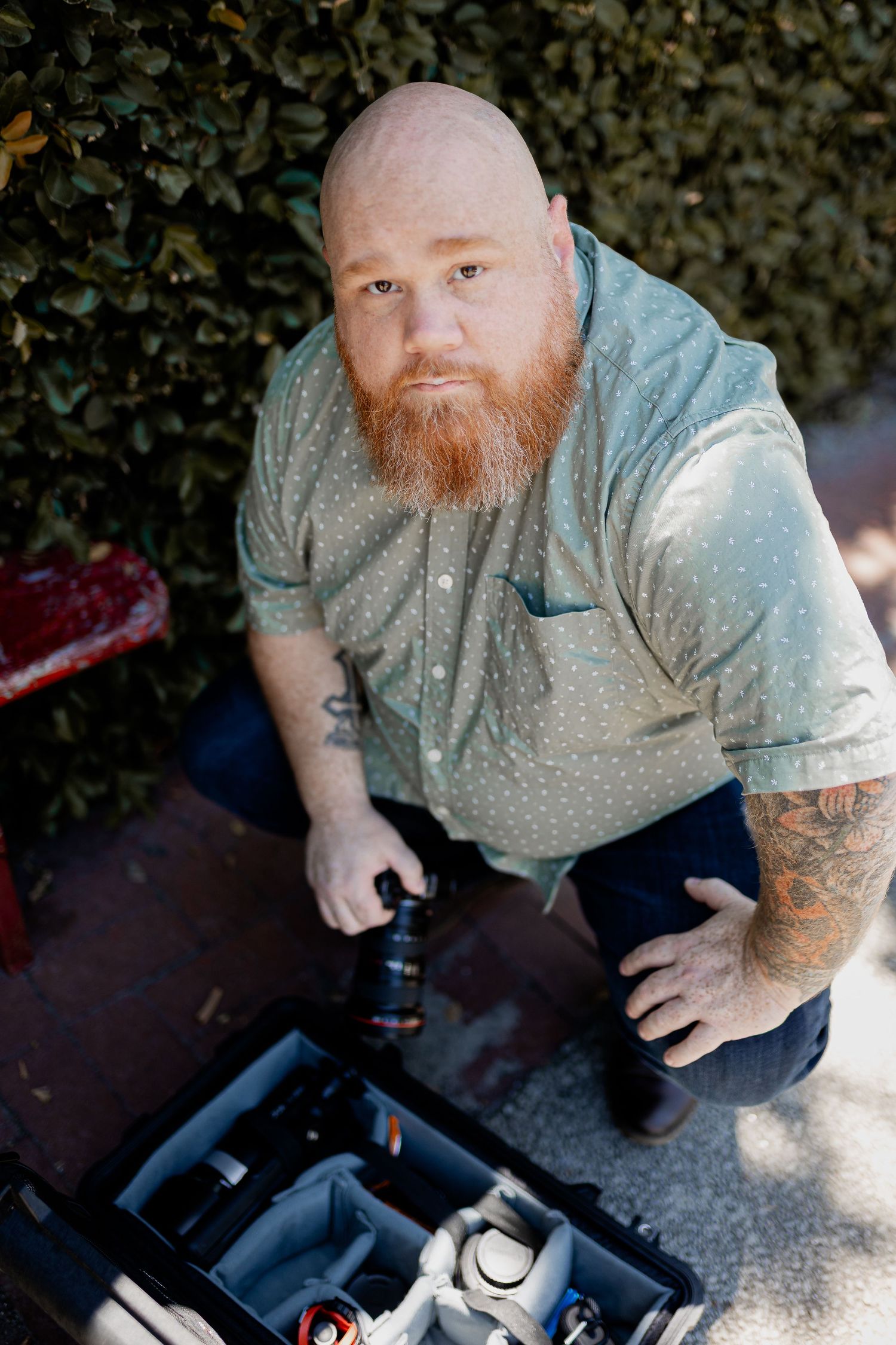 Savannah portrait photographer David Monroe —Person in gray shirt sitting outdoors looking down at camera.