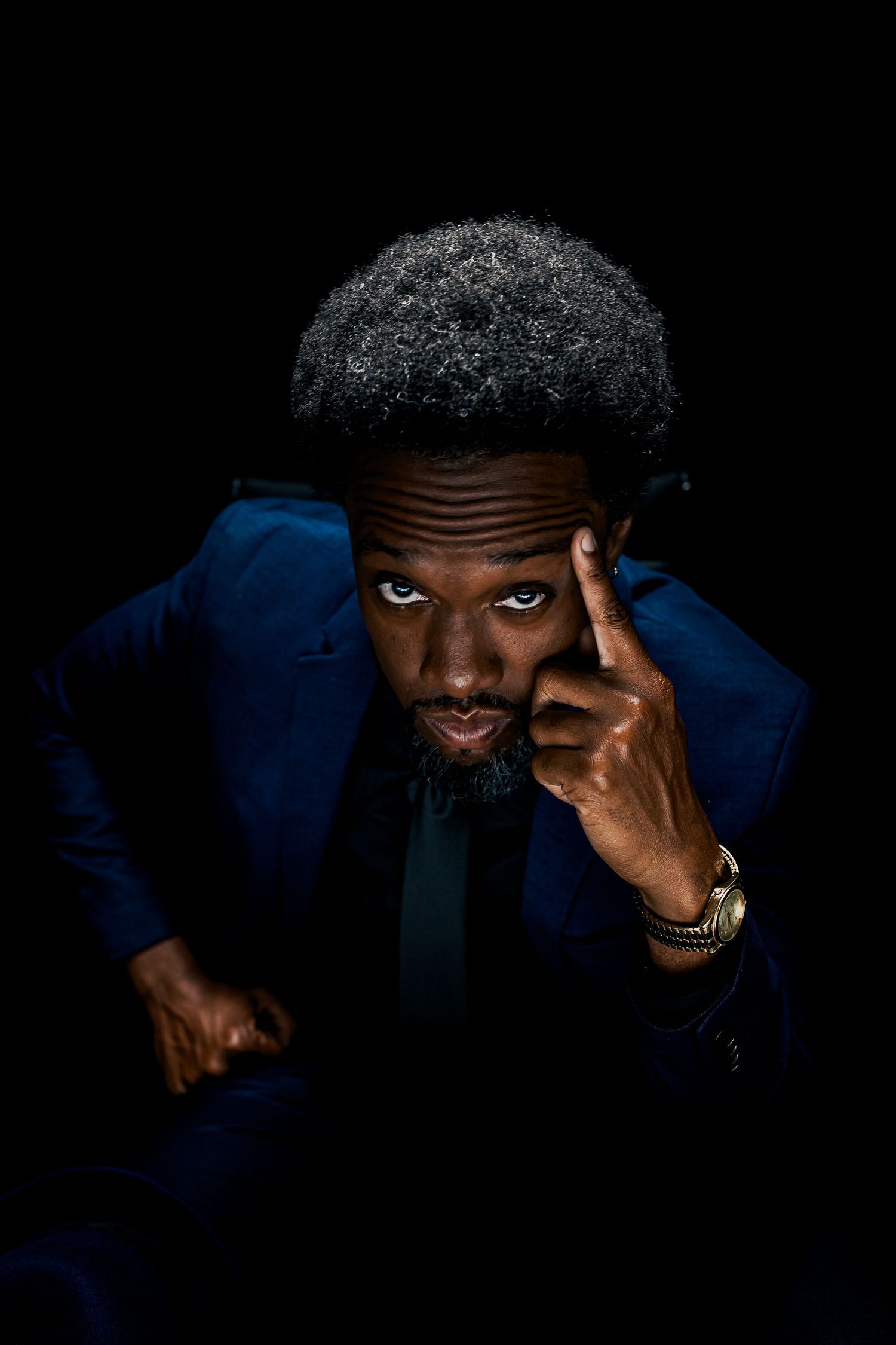 Savannah portrait photographer David Monroe —expressive eyes and gold teeth against a dark background with blue tones.
