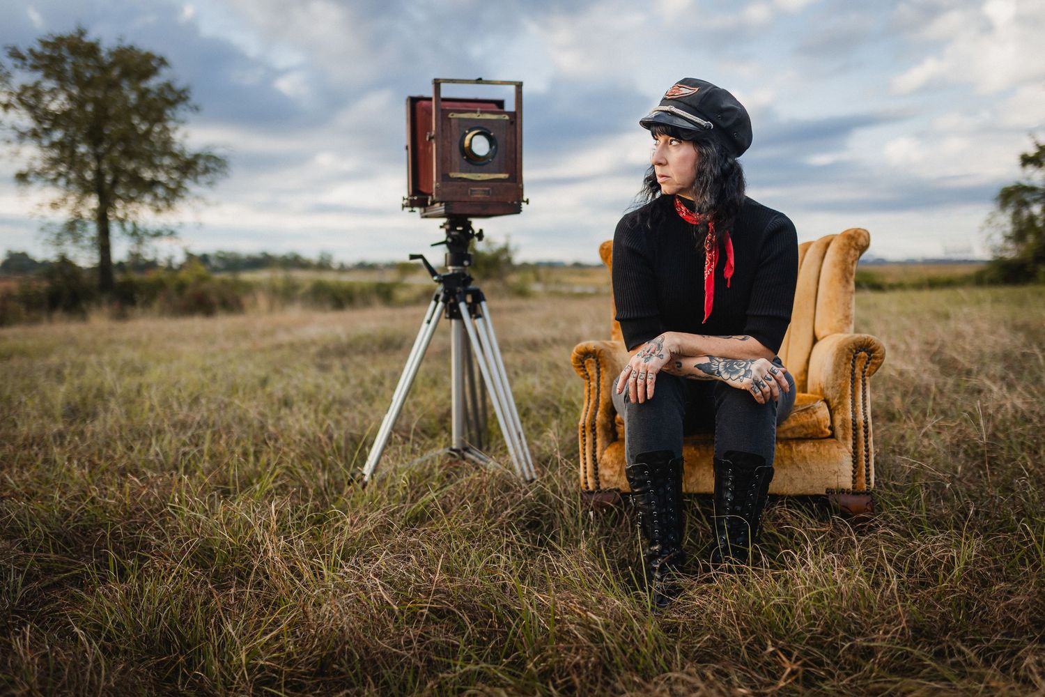 Savannah portrait photographer David Monroe — Photographer with vintage camera and leather chair in grassy field at sunset.
