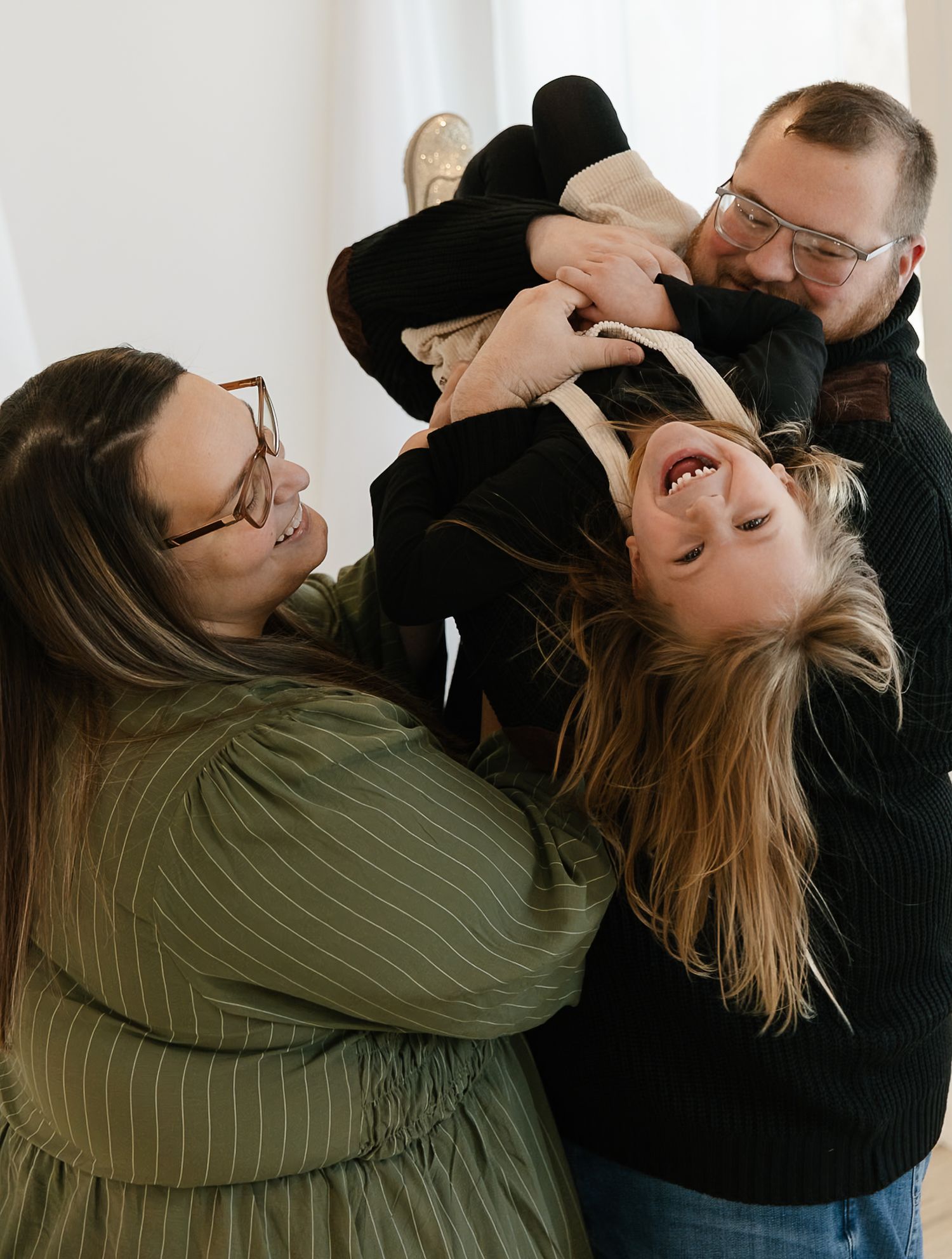 A couple embracing and playing together in a close pose against a light colored background indoor studio in Elkton SD