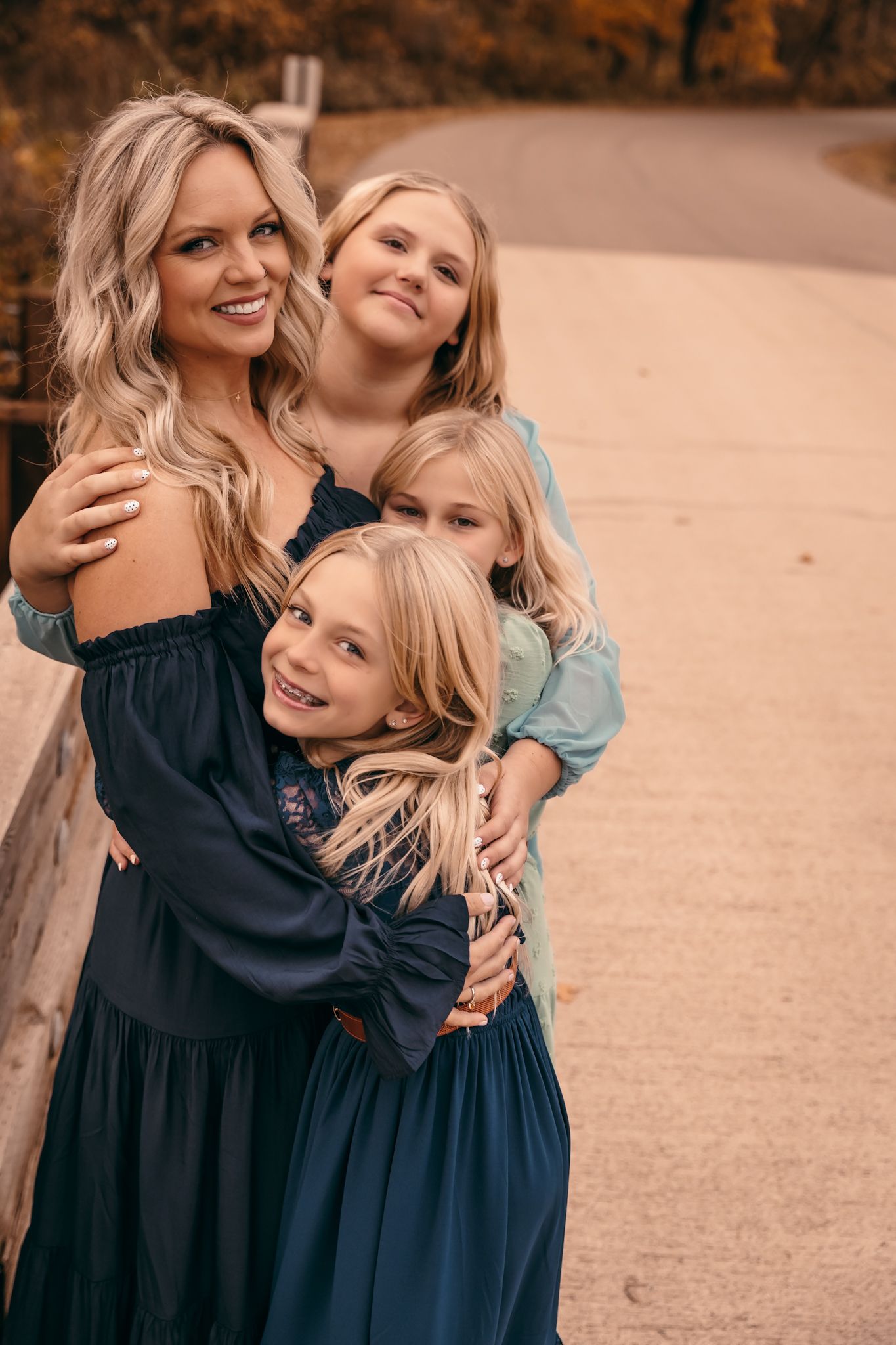 Mom & kids in coordinating navy & light blue dresses share joyful embraces outdoors in a series of candid moments in Lynd MN at Camden State