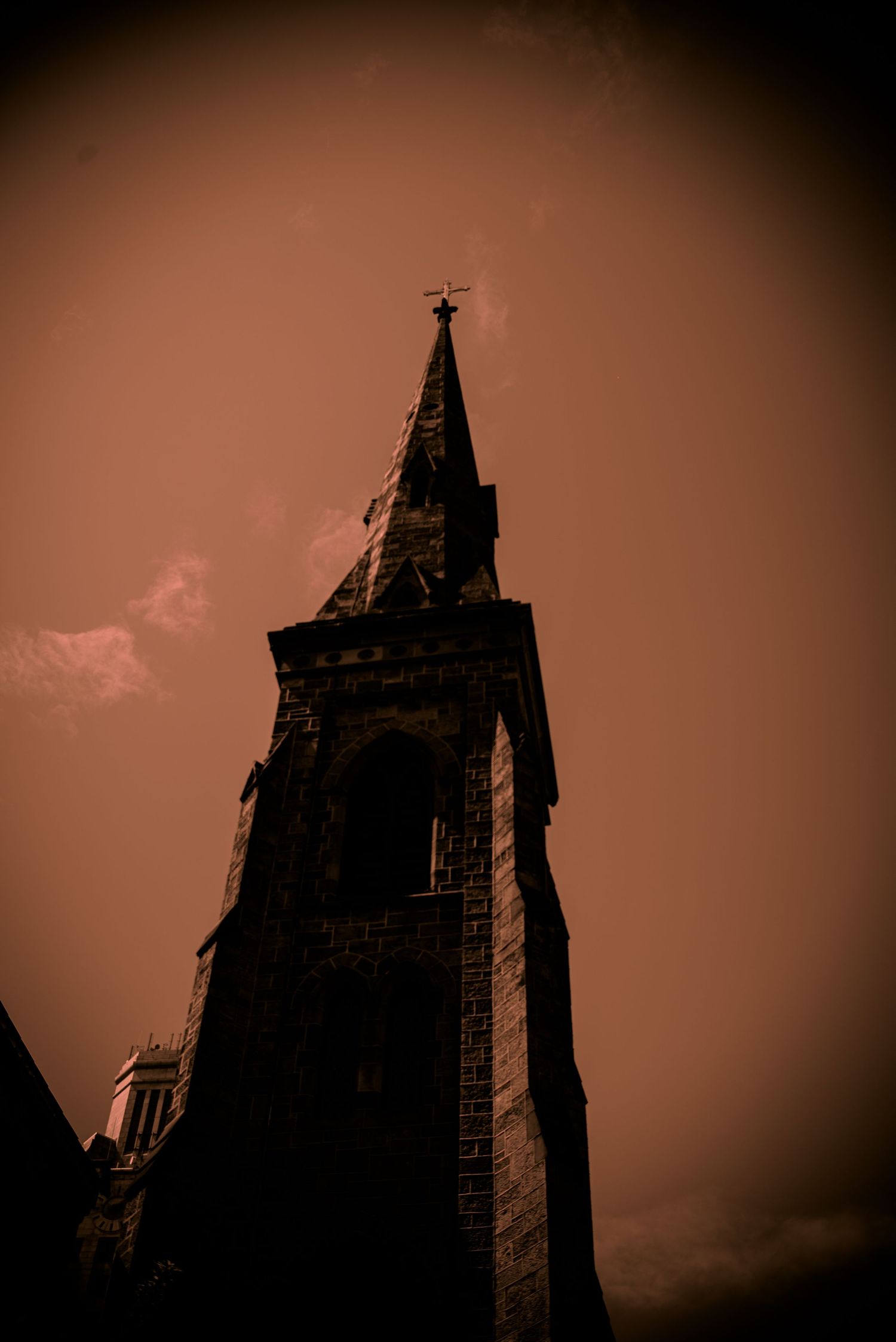 Church steeple, sepia in color with dramatic shadows and a black vignette.