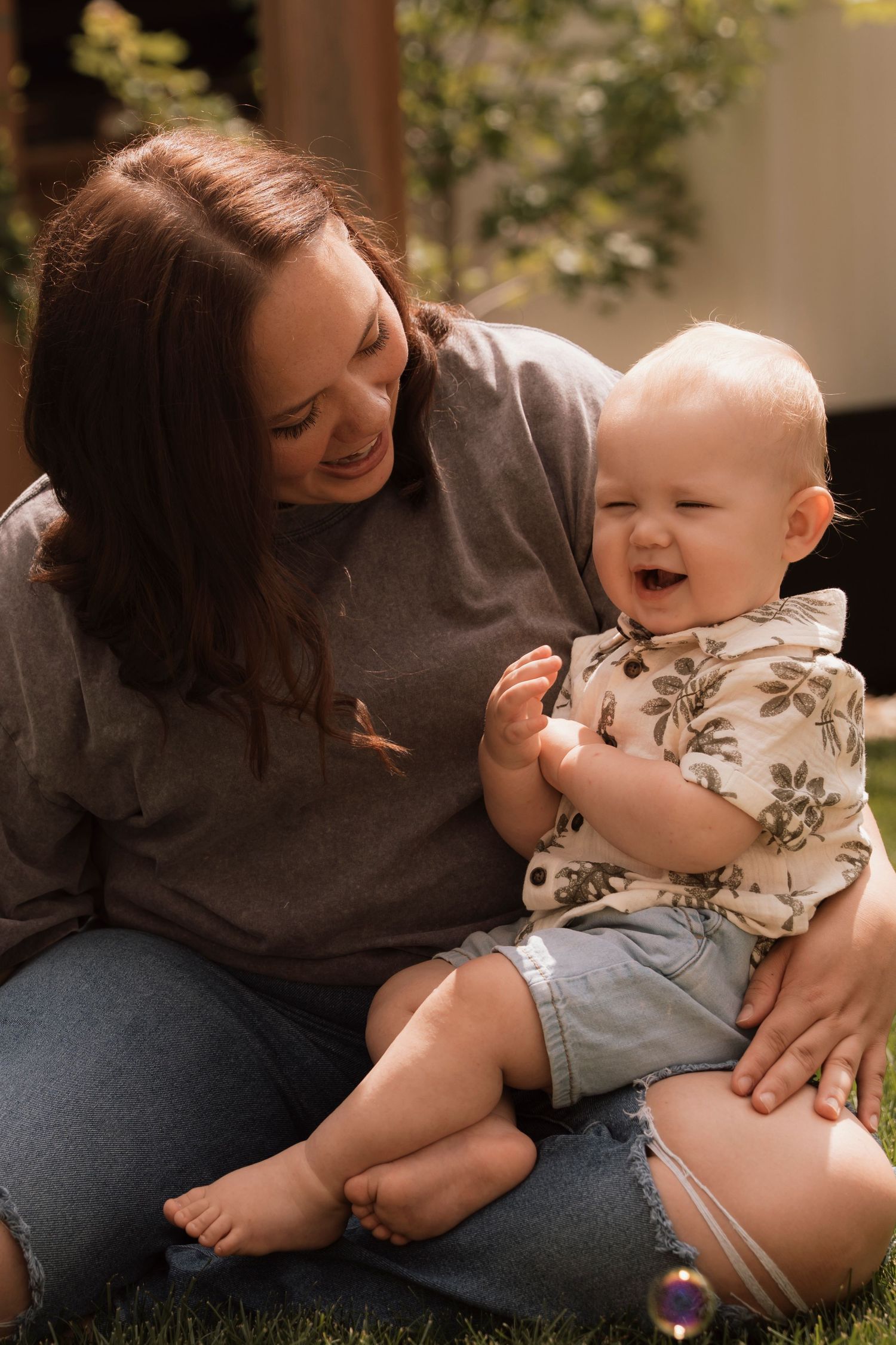Sweet outdoor moments of play and laughter between adult and baby on grass. Regina Saskatchewan Family portrait photographer.