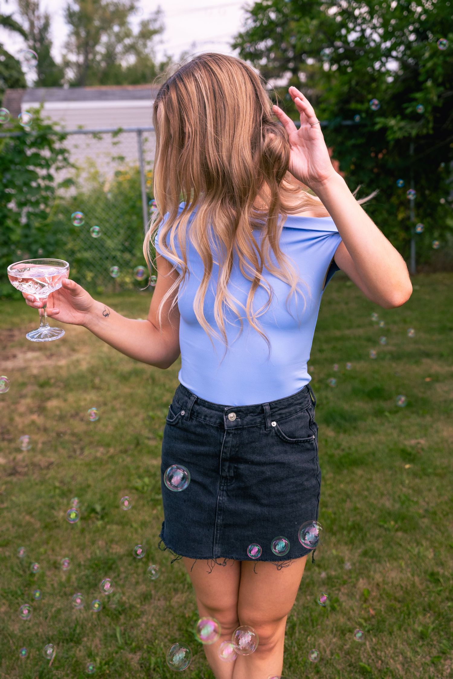 A series of soap bubble images showing someone in denim shorts and blue shirt creating bubbles in a grassy outdoor setting.