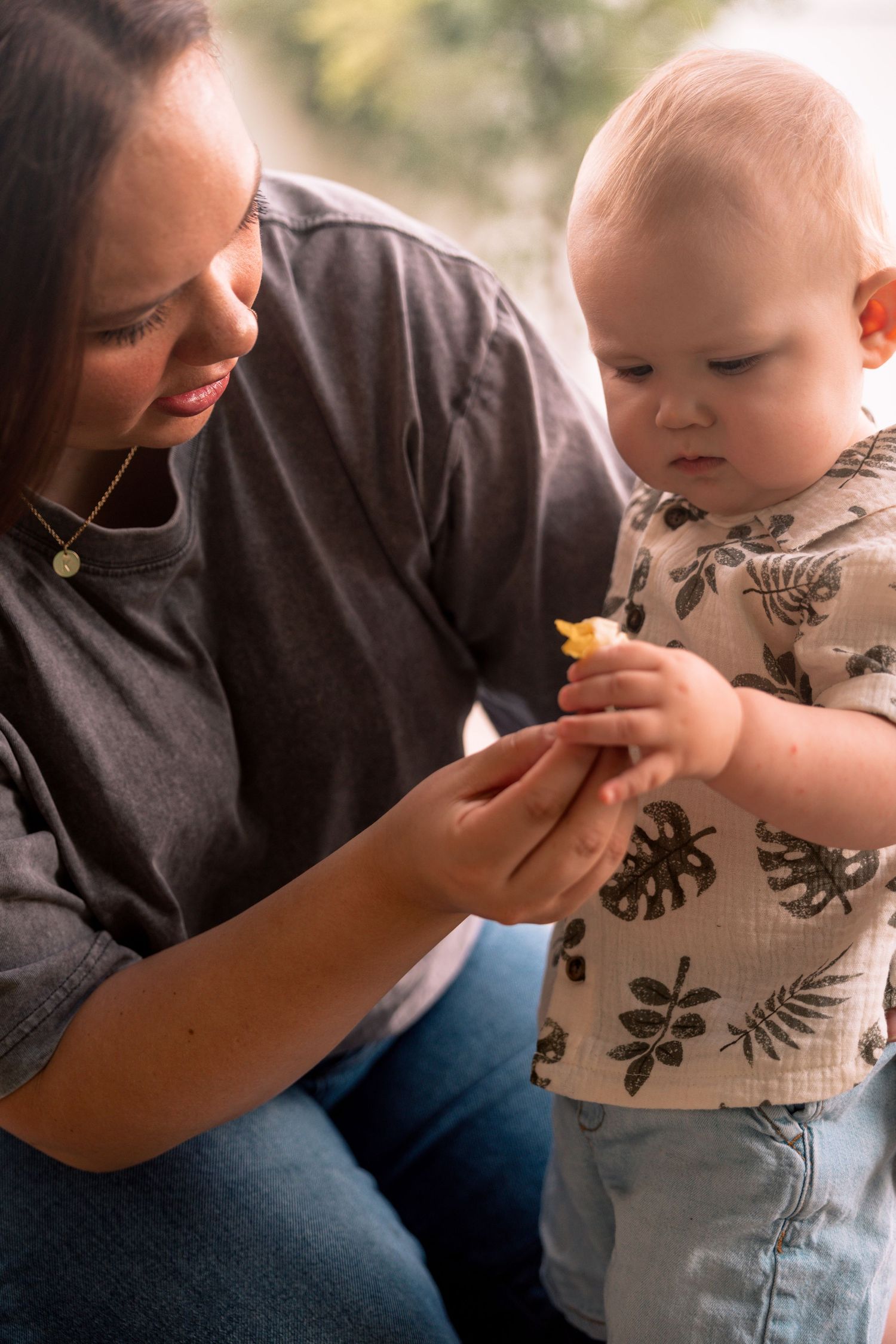 Intimate feeding moment between adult and baby wearing patterned clothing.Regina Saskatchewan Family portrait photographer.
