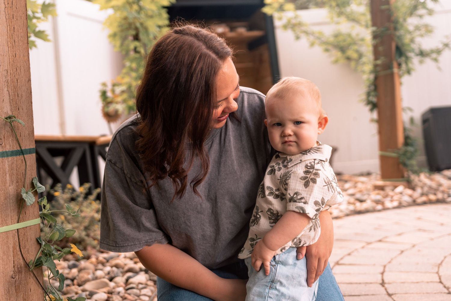 Sweet candid family moment captured outdoors with mother and child during golden hour photoshoot.