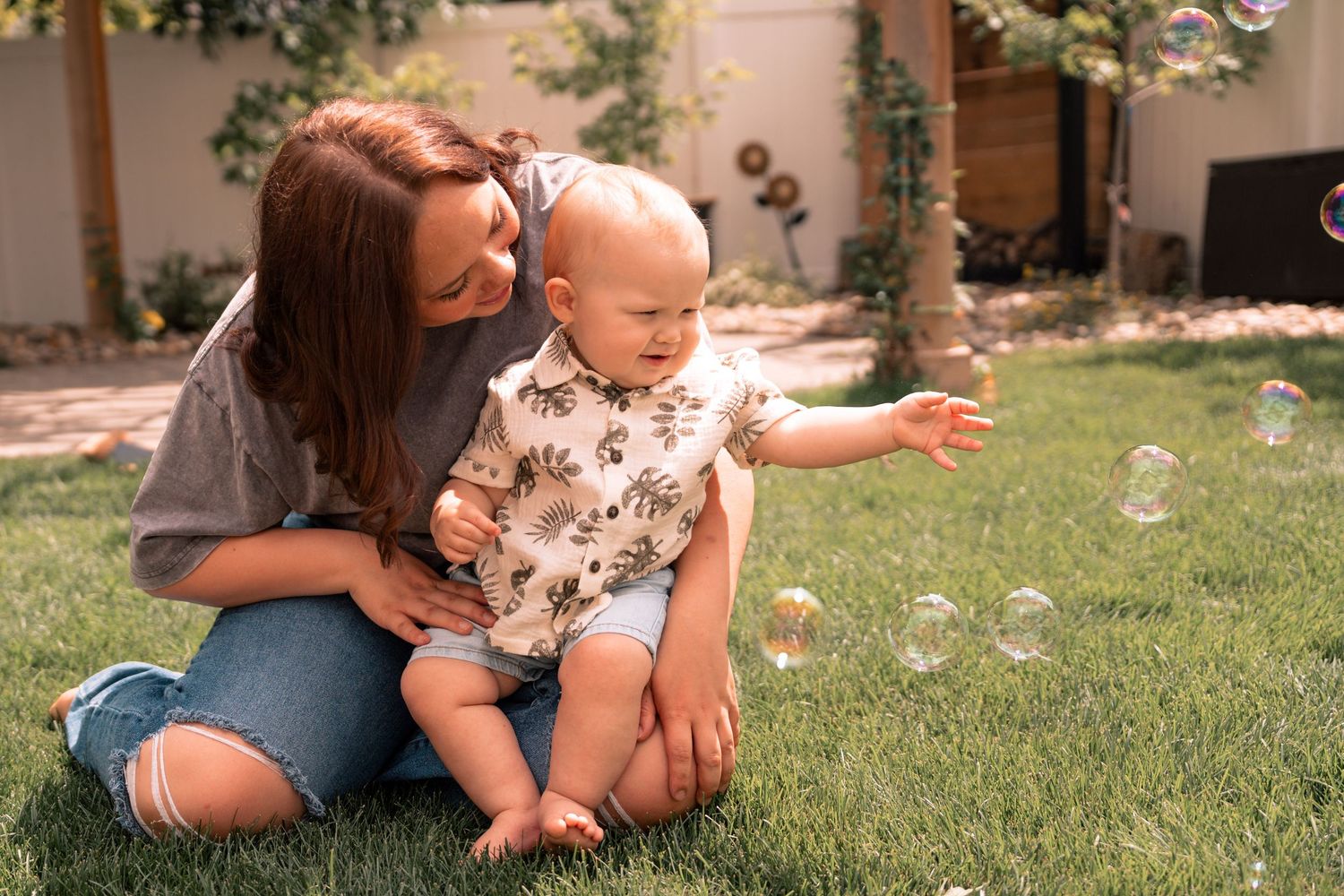 A group of images shows caretakers and toddlers playing with bubbles in a sunny garden setting.