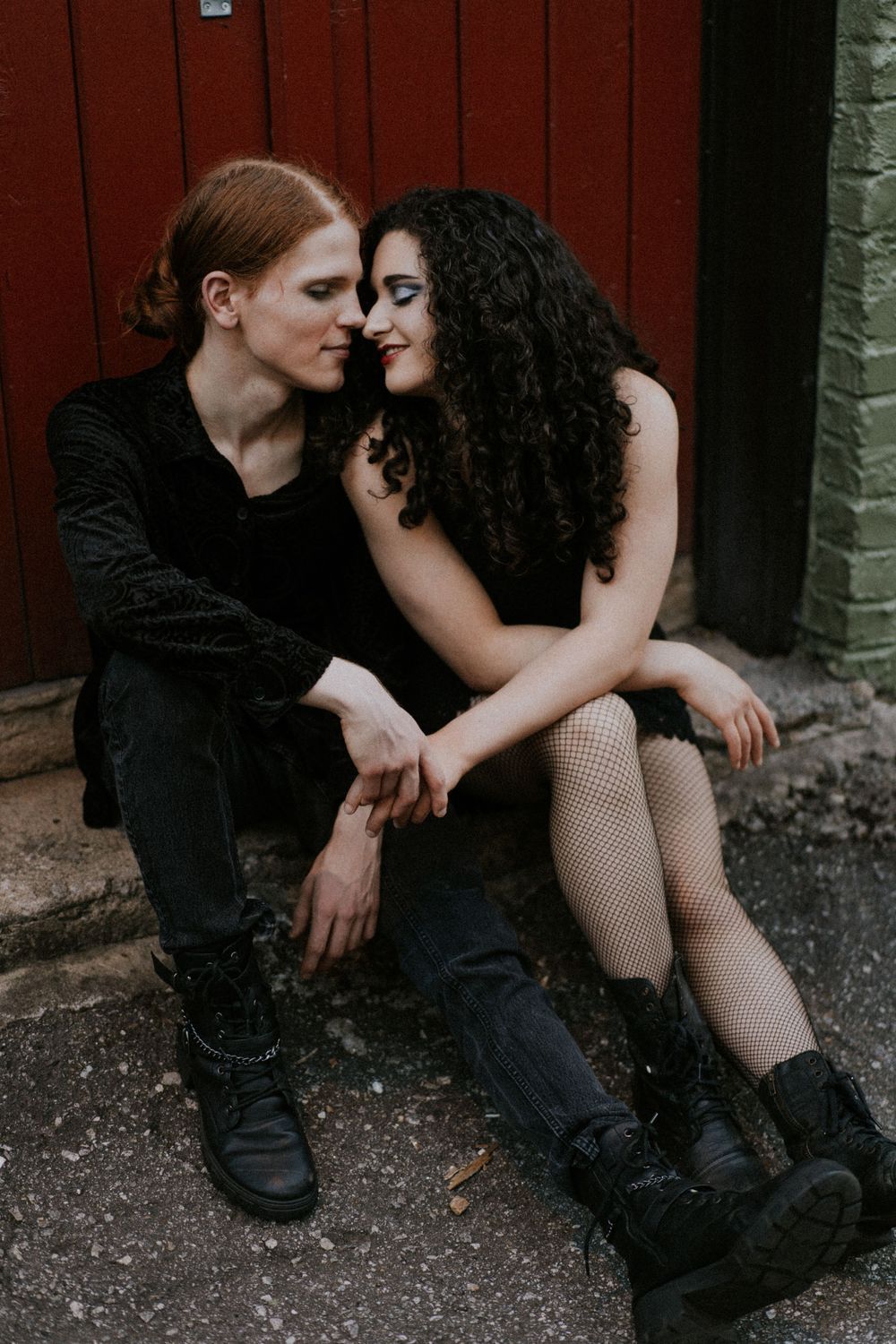 Intimate couple portrait session against brick wall background.