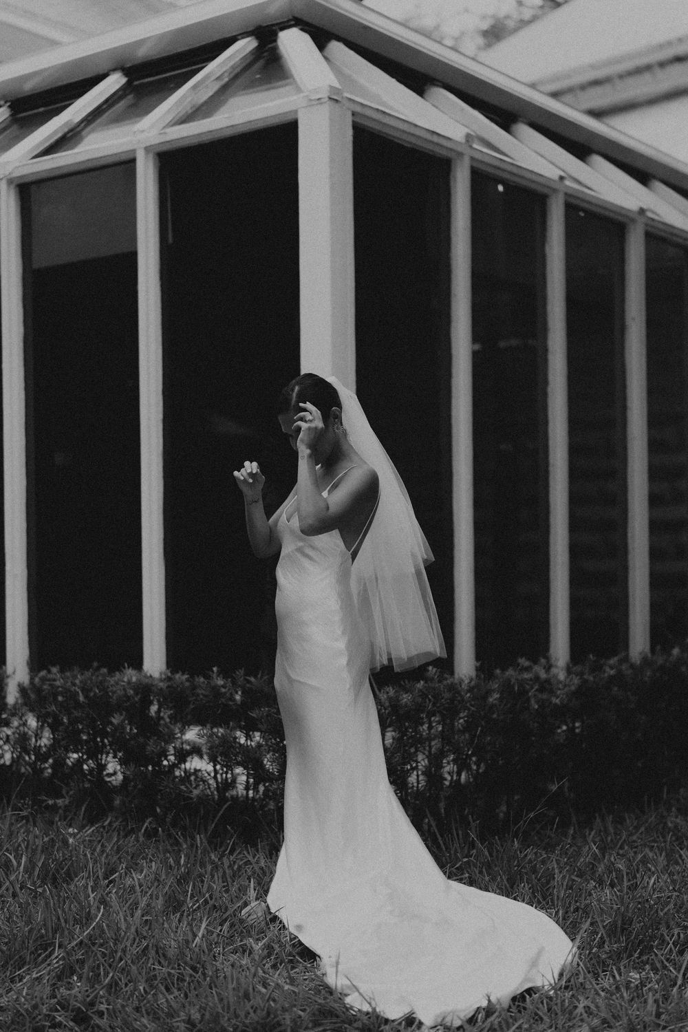 Black and white photos of a bridal dress through architectural columns and railings.