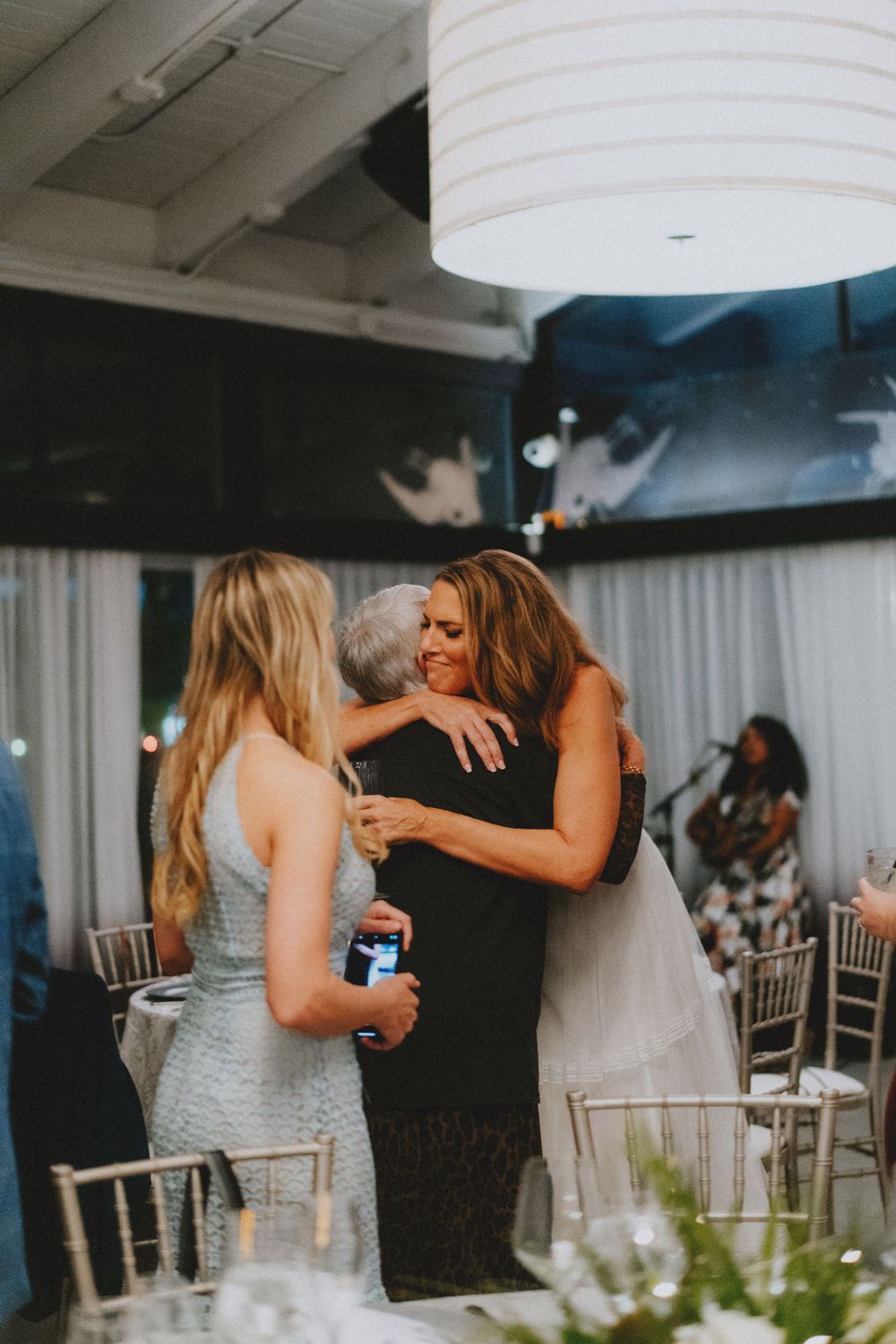 Wedding guests embracing during reception celebration.