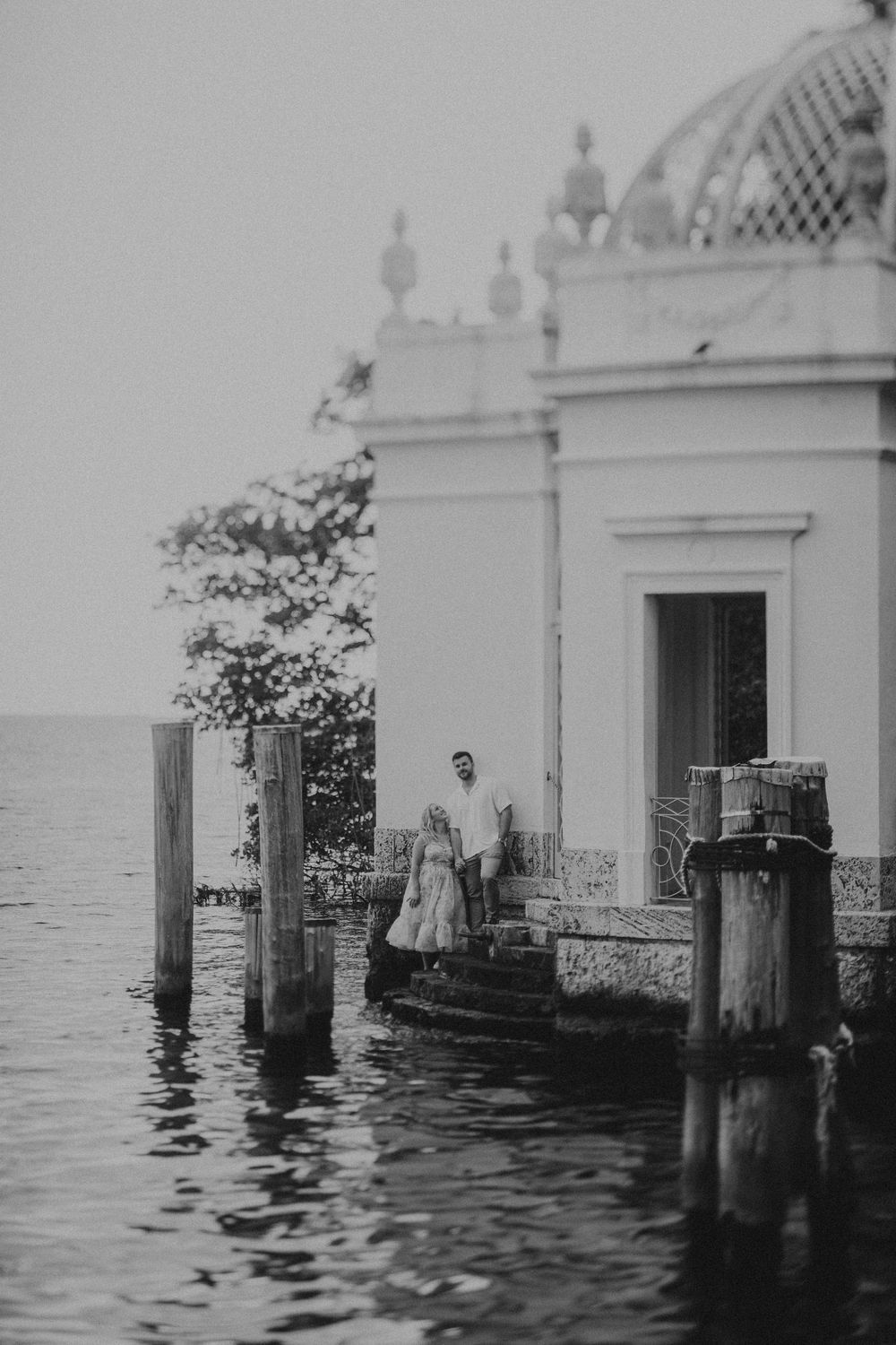 Historic black and white photograph of ornate waterfront architecture with decorative pillars.