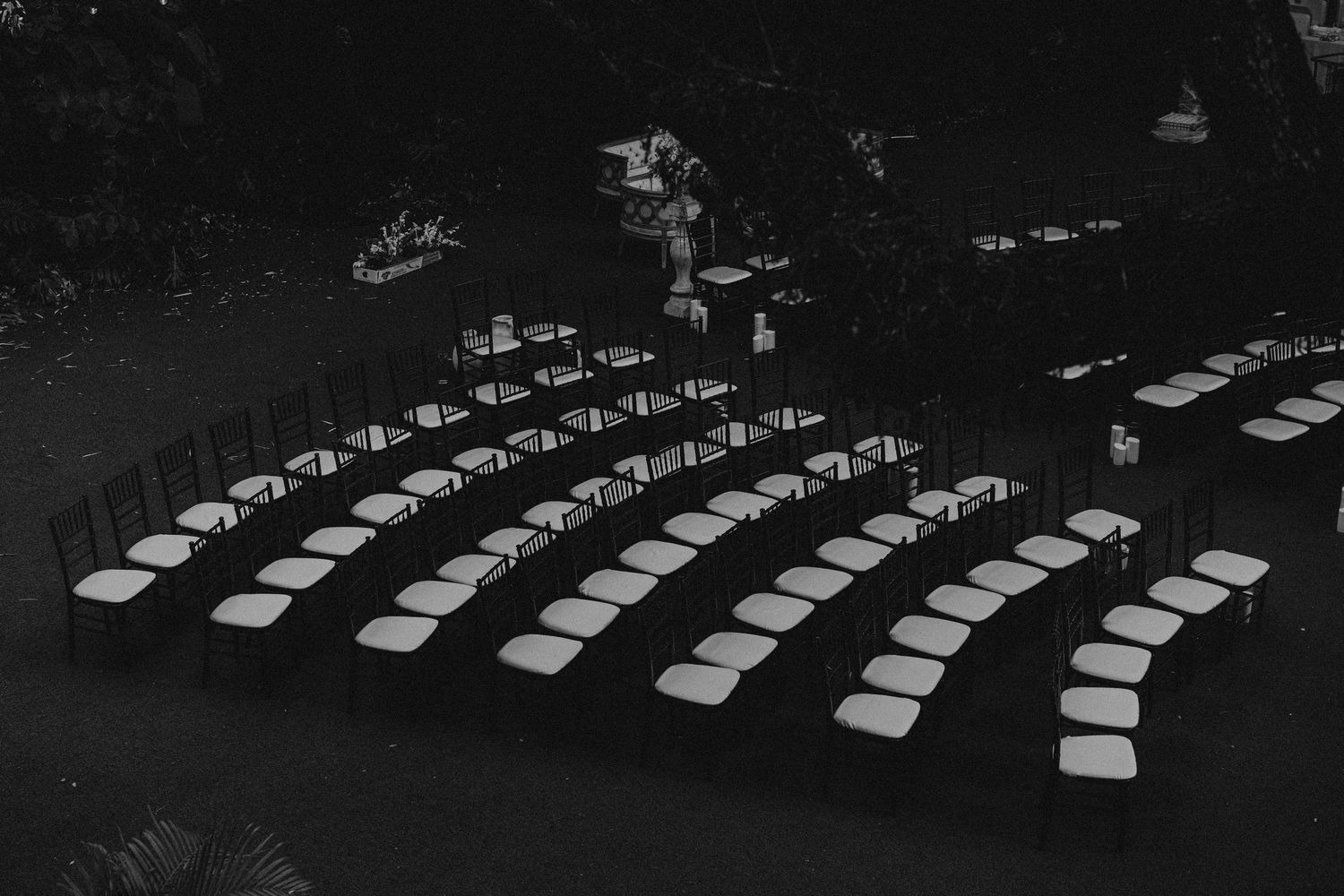 Aerial black and white photo of rows of white chairs arranged for an outdoor event near a waterway.