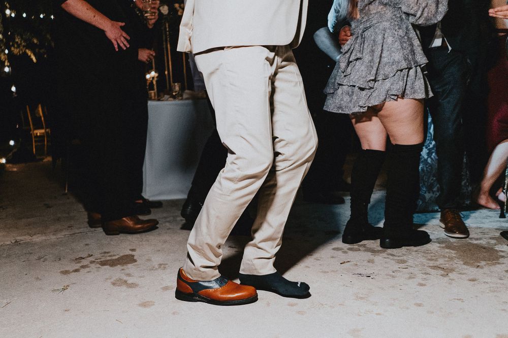 Low-angle shot of wedding guests' feet dancing at a reception.
