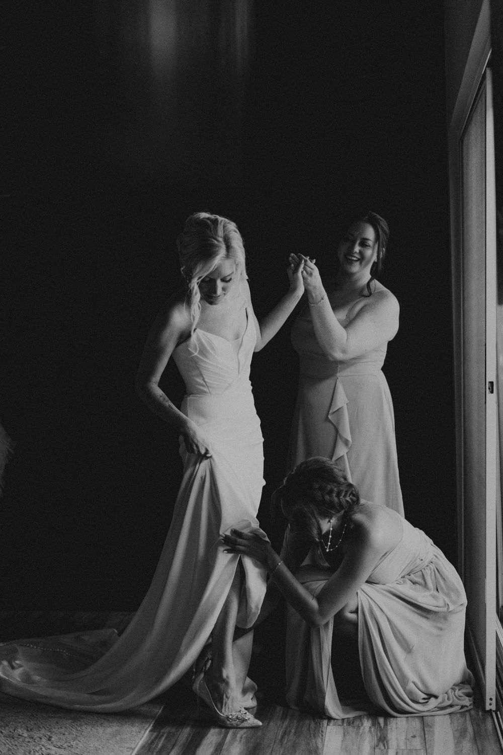 Silhouettes of people in wedding attire posing dramatically against a dark background.
