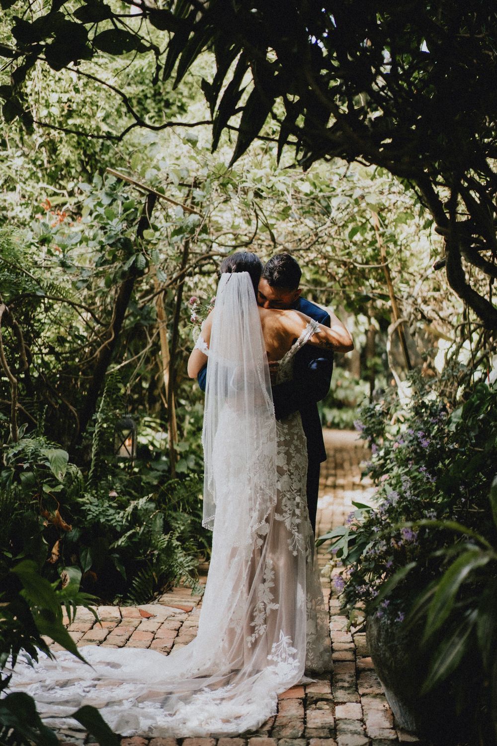 Ethereal bridal veil trailing through a lush garden pathway.