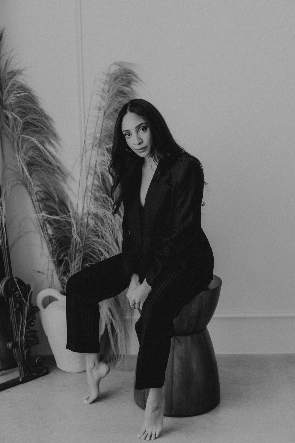 Artistic black and white portrait session featuring minimal styling against a light backdrop.