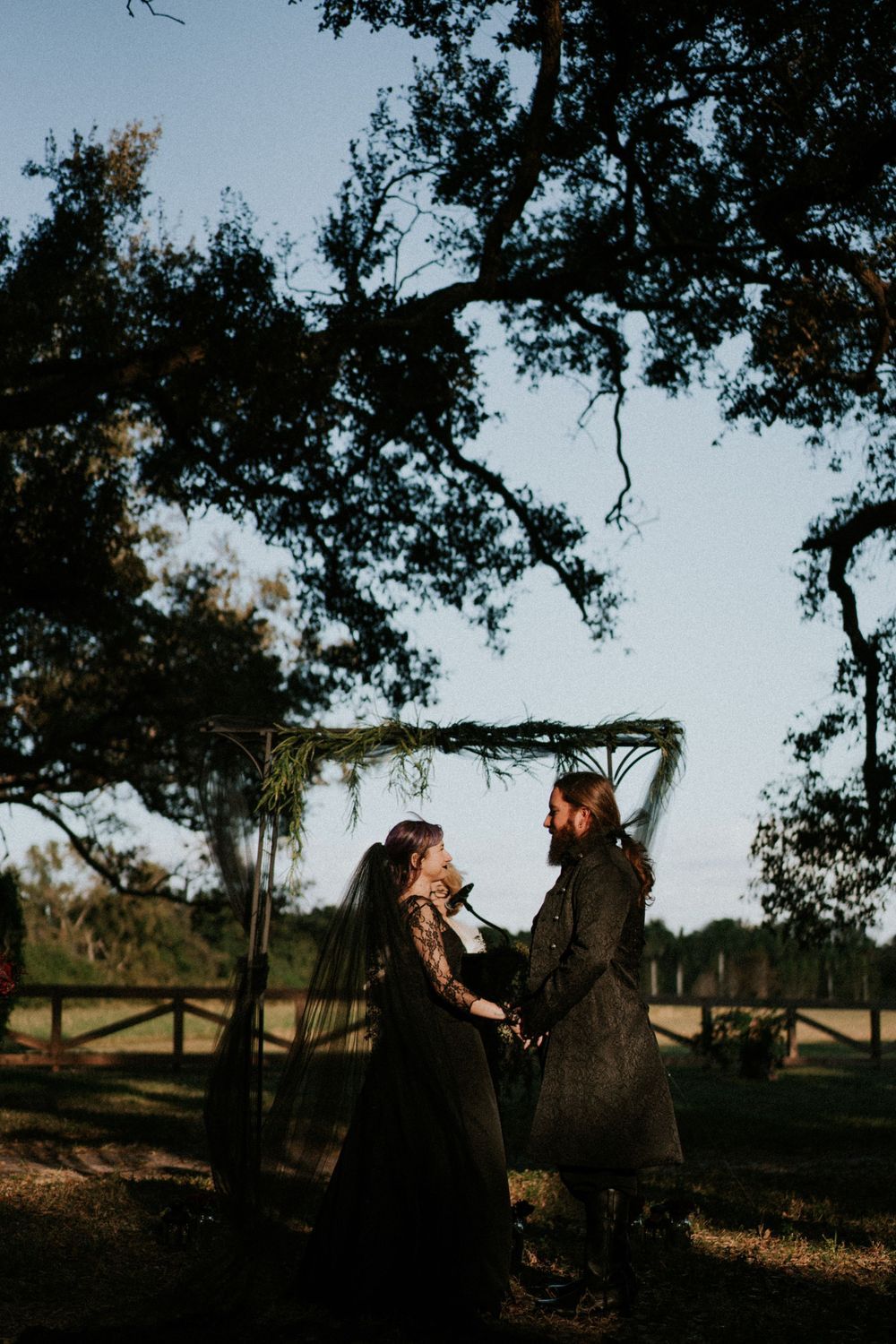 Romantic outdoor portrait session under massive oak trees at sunset.