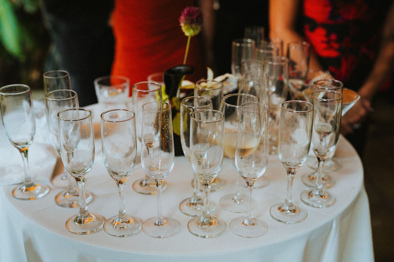 Elegant champagne flutes arranged on a white tablecloth at a formal event or wedding reception.