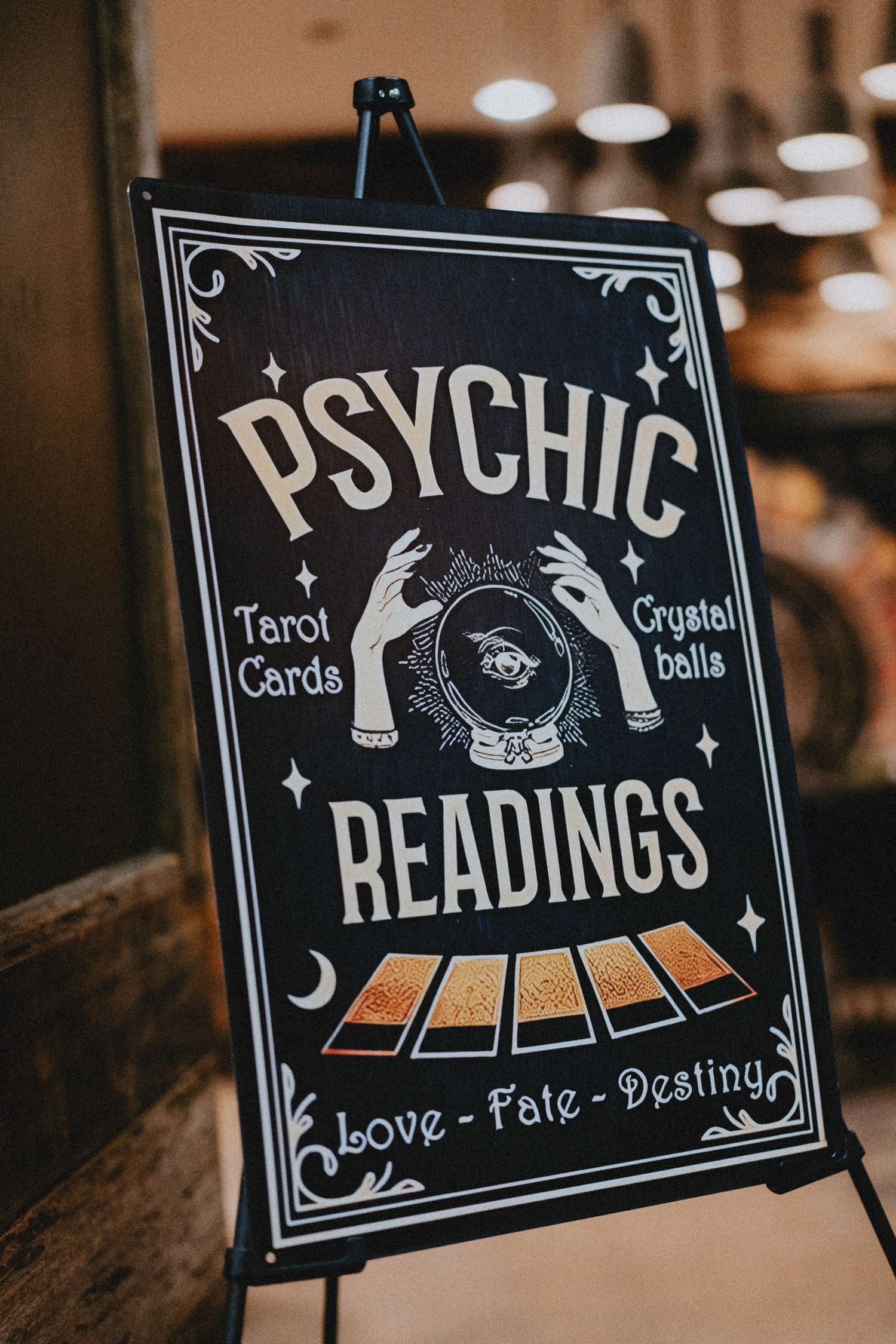 Decorative psychic readings sign featuring tarot cards and crystal ball for a wedding reception.