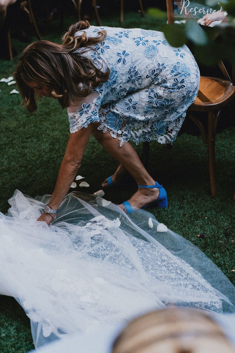 Close-up shot of someone rolling out what appears to be tulle fabric or netting on grass outdoors.