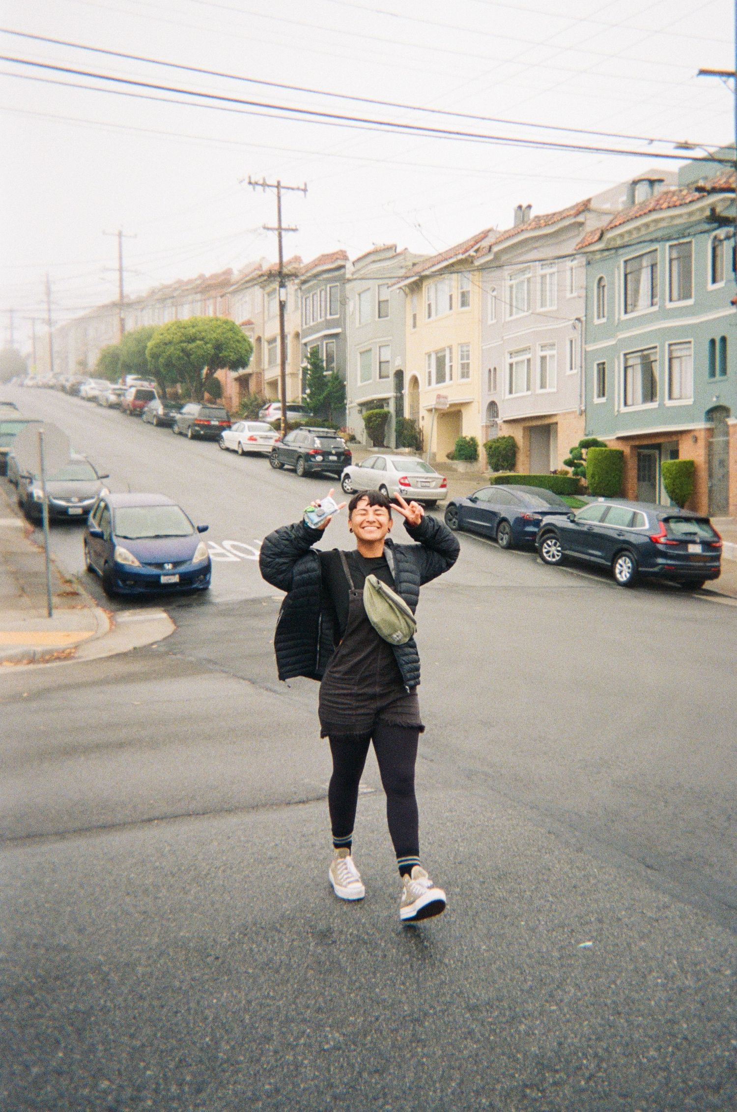 Person performing acrobatic moves on a residential street lined with houses.
