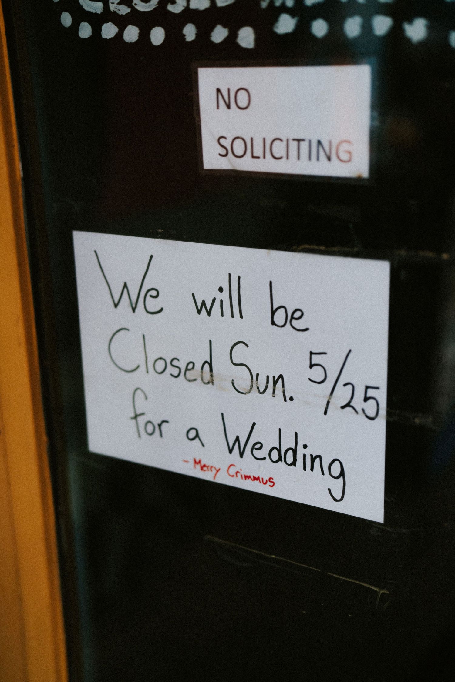 Handwritten sign on door reads closed Sunday 5/25 for a wedding signed Merry Crimmus.