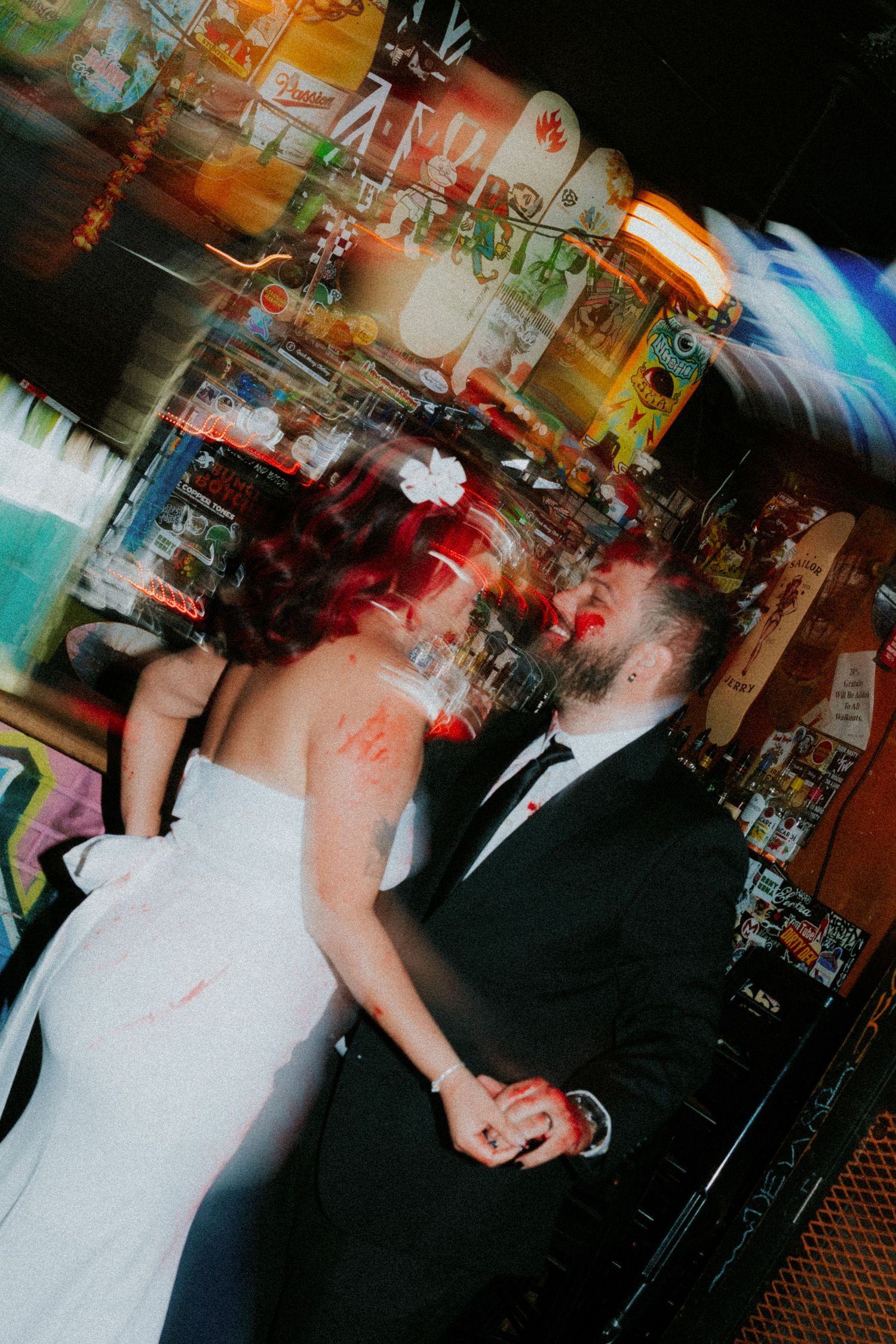 Bride and groom share a romantic first dance in a vibrant, motion-blurred wedding reception venue.