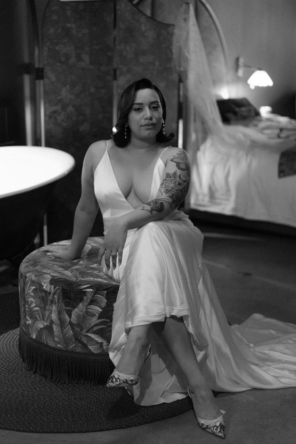 Black and white portrait showing wedding dress details and luxury seating.