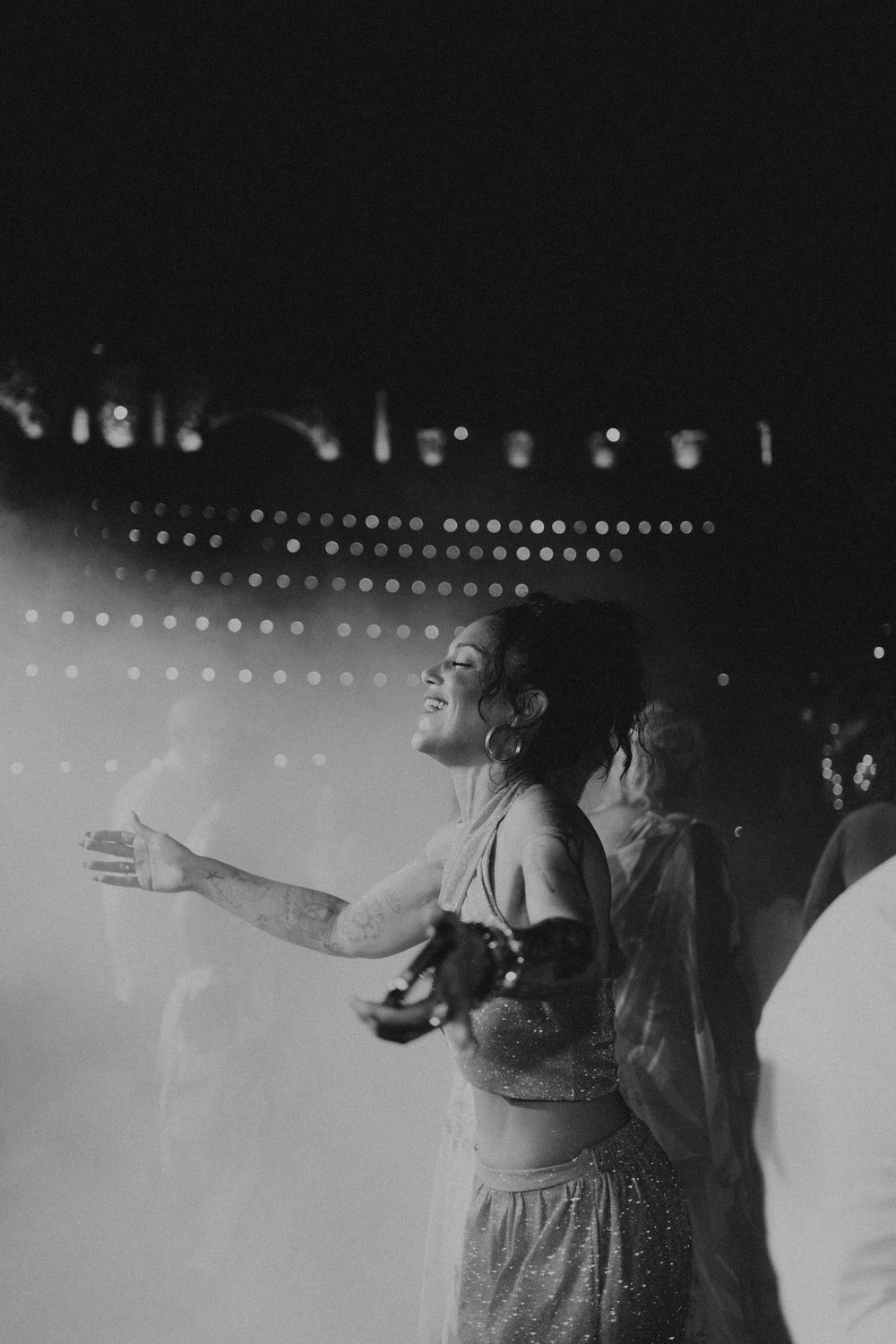 Black and white photograph showing silhouettes against stage lighting.