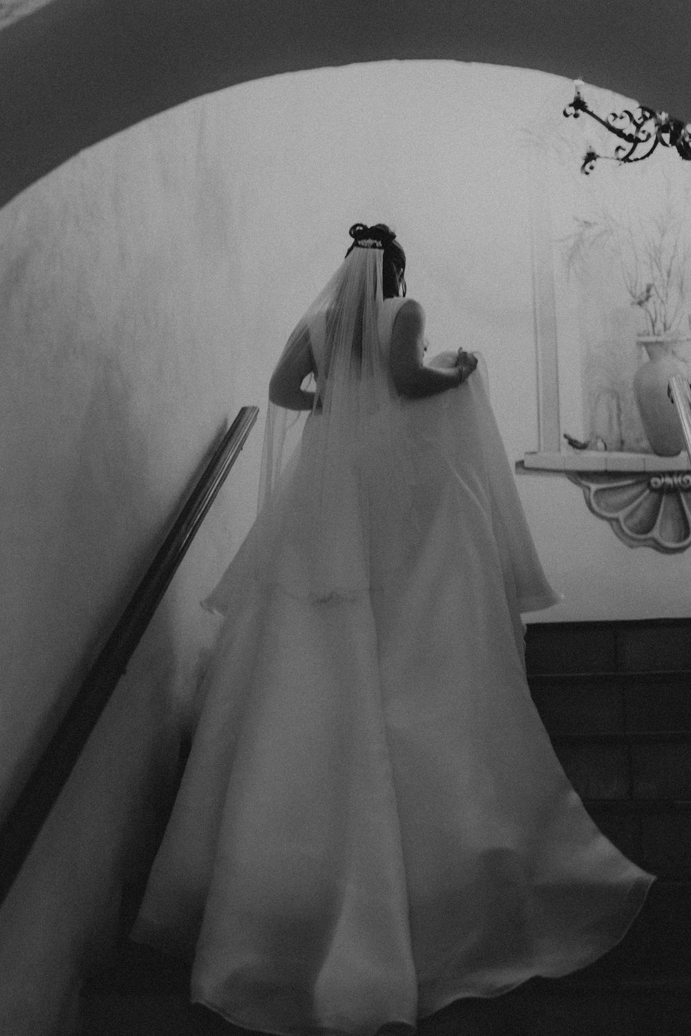 Flowing wedding dress silhouette captured in dramatic black and white.